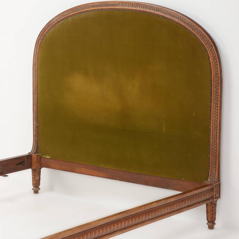 French Provincial A carved walnut French bed having a shaped head and footboard circa 1920.