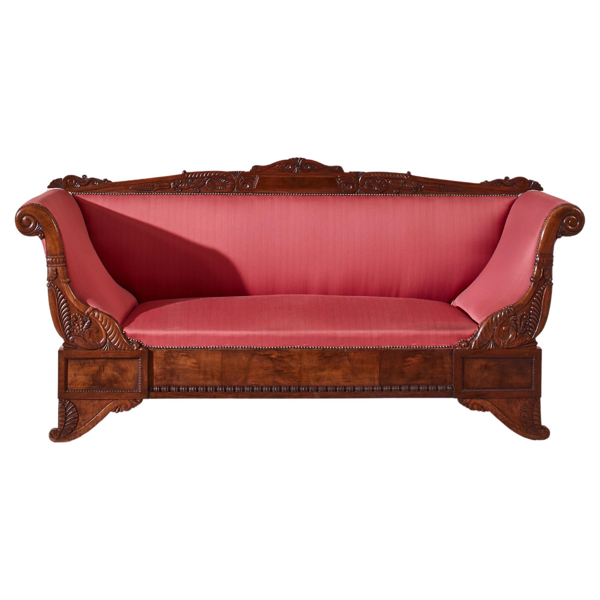 A carved walnut sofa with boat-shaped form in the style of Henry Thomas Peters