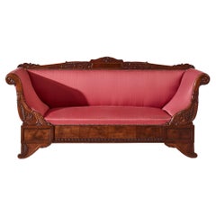 A carved walnut sofa with boat-shaped form in the style of Henry Thomas Peters