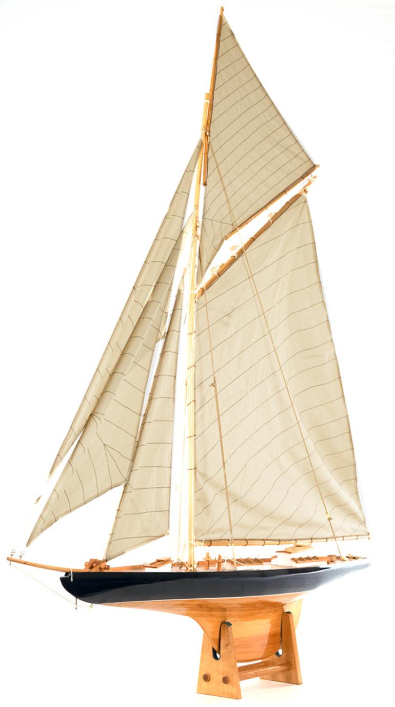 A Mid-Century Modern wood and linen model of a sailboat.