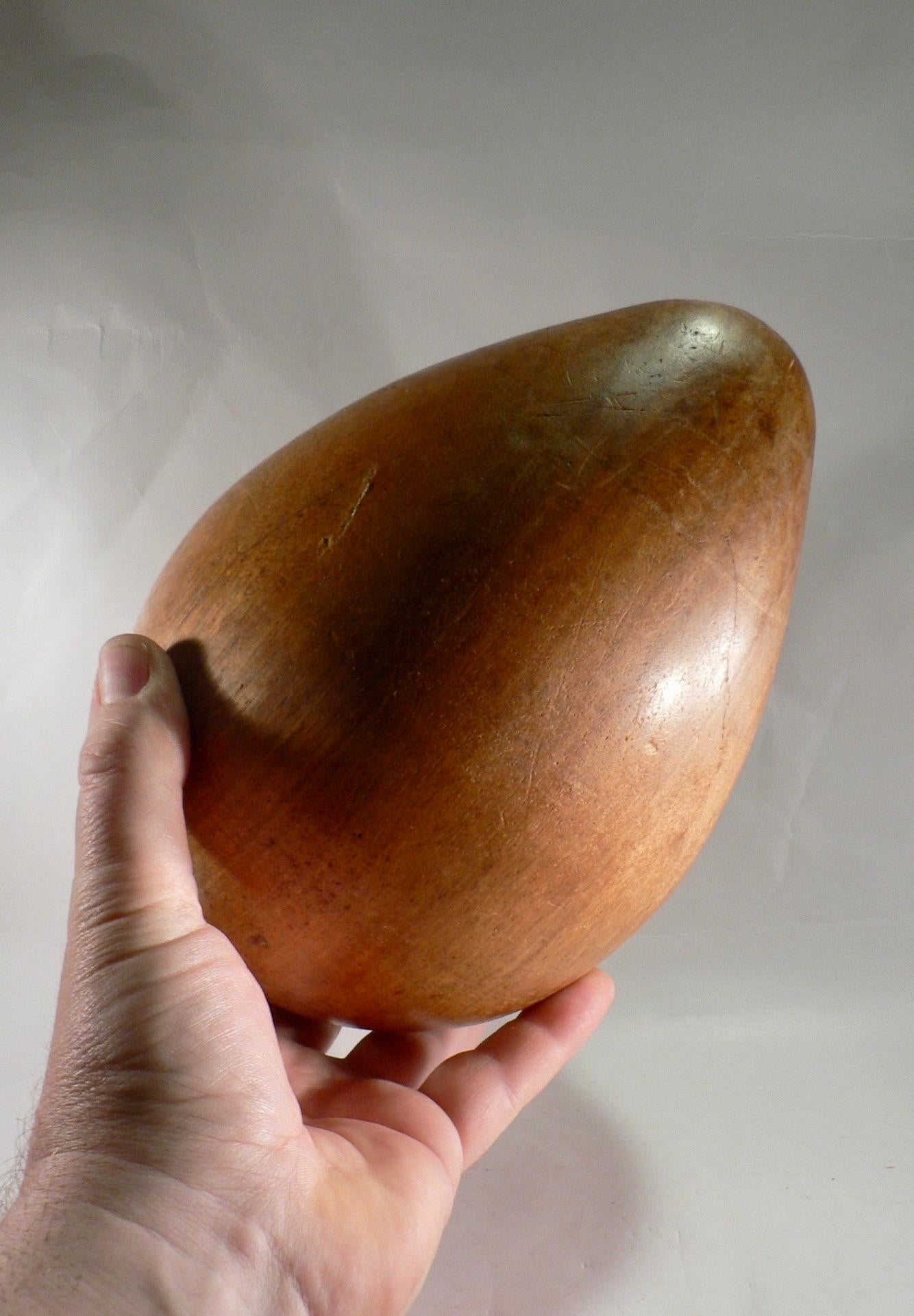 A carved wooden egg, likely made in the 1950s in France. This type of object was popular at the time and is often considered a beautiful decorative item. Carved eggs were often crafted by hand, typically turned on a lathe, resulting in a smooth and
