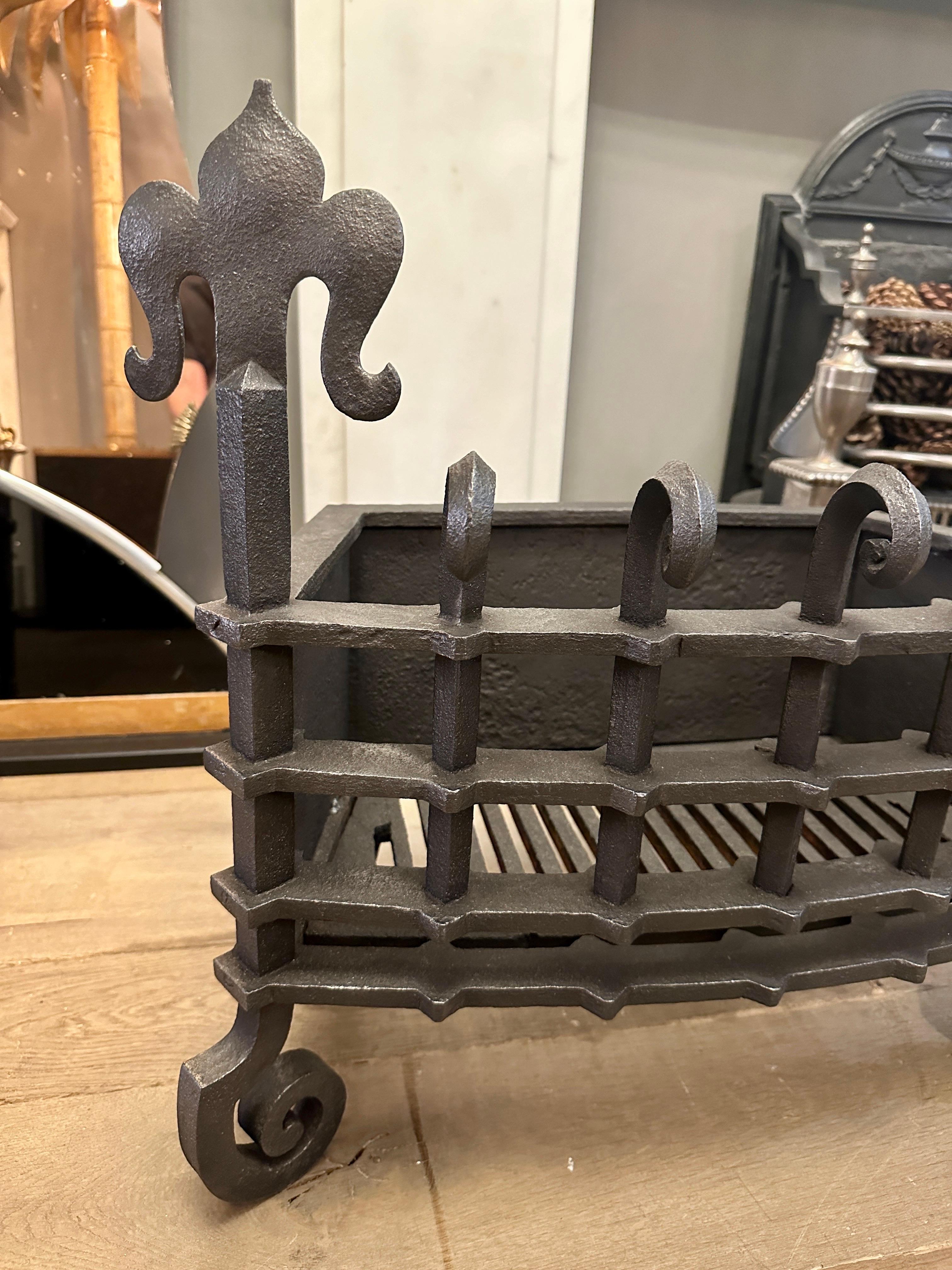 A bow fronted wrought and cast iron fire grate. The fortress style burning area with scrolled tops and foliate finials. Scrolled front supports, tapering back to a low back and plain back legs. Original internal grate. Late 19th Century English  