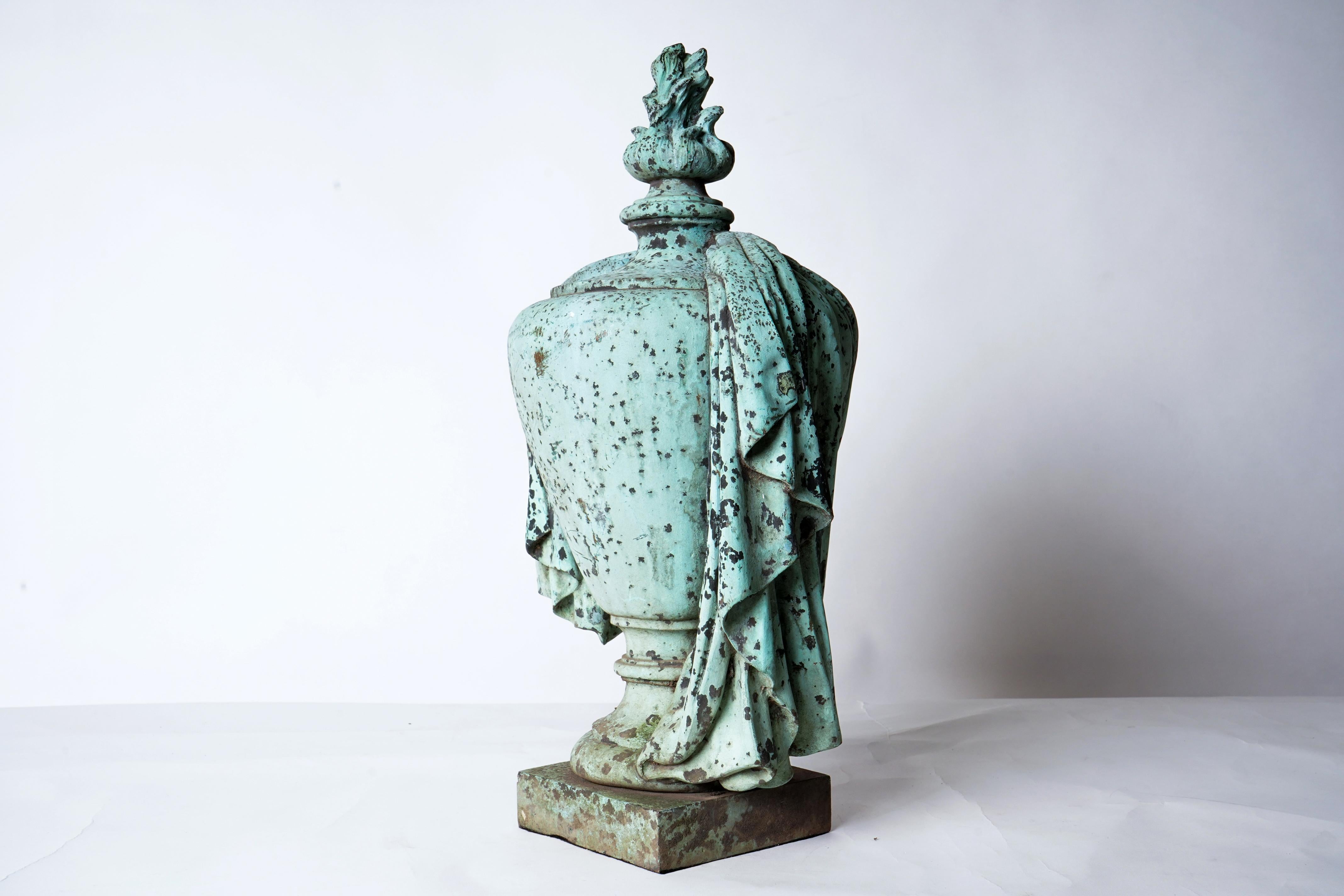 This classical garden urn is made from cast iron and painted green to resemble aged copper or bronze.
 