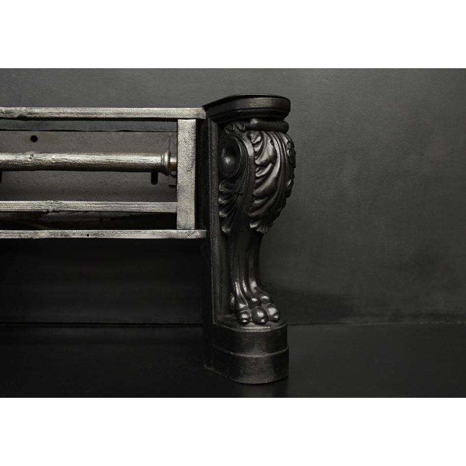 Une grille à feu en fonte inhabituelle. Les pieds à double plinthe et à patte de lion à la base, surmontés de rinceaux de feuilles d'acanthe et d'une coiffe. La zone de combustion est équipée de barres en fonte patinée et polie. Anglais, 19e siècle.
