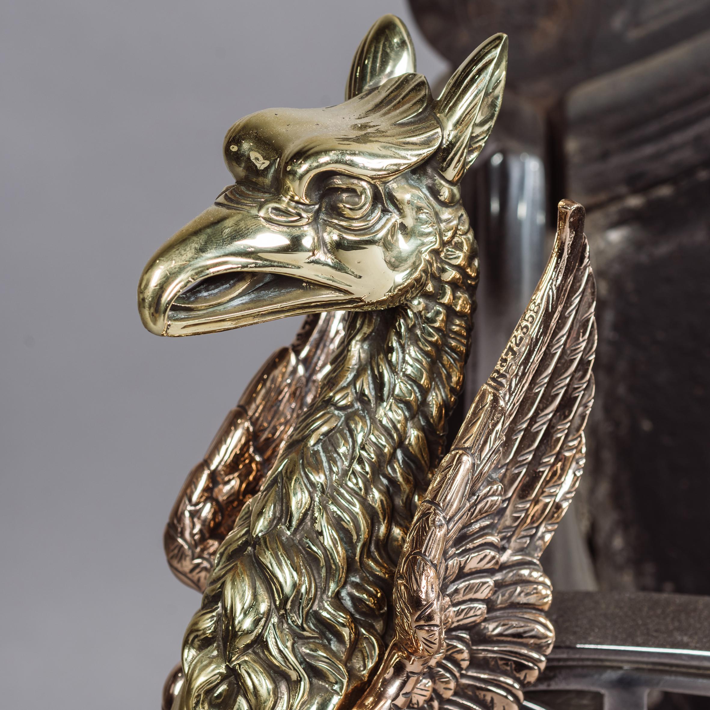 A cast iron, steel, copper and brass fire grate, cast with winged griffins.

The architectural back cast with roundel and ribbon tied pendant swags, the serpentine bowed front on winged griffin supports and claw and ball feet. 

English, circa