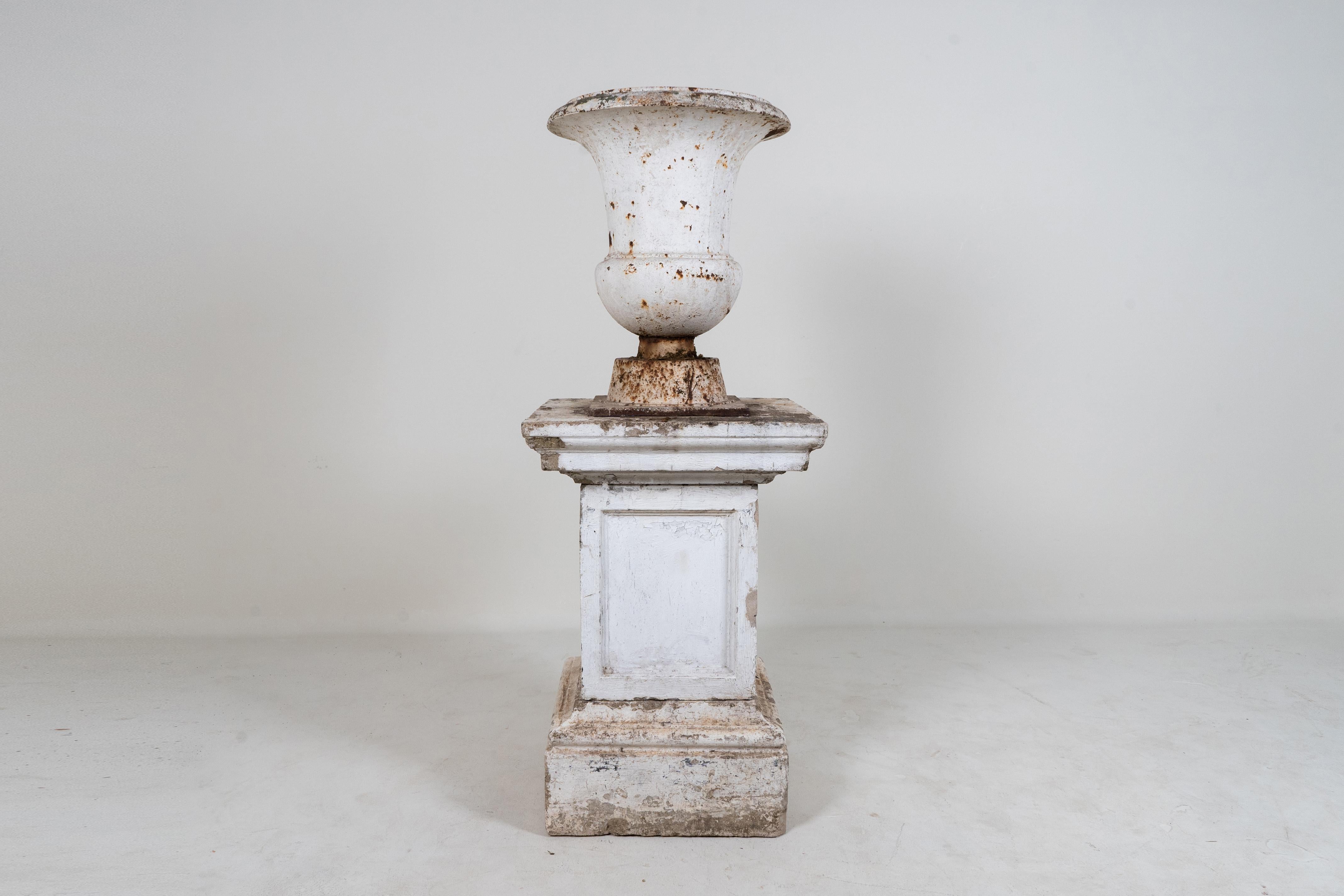 A French cast iron Provençale jardinière from the early 20th century, with ancient Greek design and minimal decoration. This bell-shaped krater features a large, unadorned lip, overhanging the smooth belly, standing on a simple square base. adorned