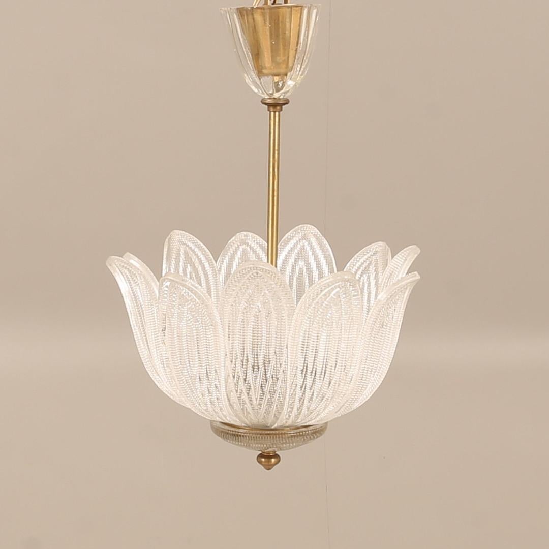A Swedish Orrefors ceiling fixture designed as a lotus flower, featuring petals made of individual sections of textured clear glass. It reflects light beautifully, and the individual leaves conceal three medium sockets. Including UL Wiring. 