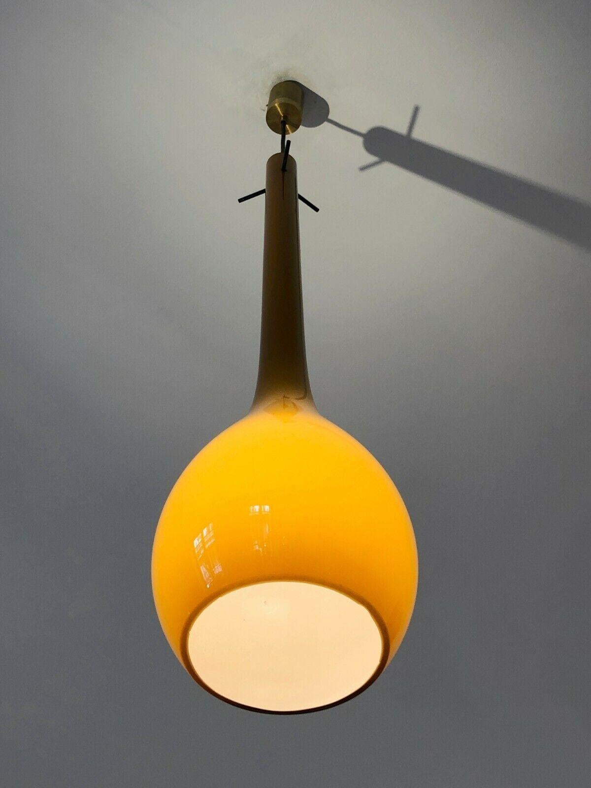 An exceptional ceiling light in the form of a long drop or tear, Moderniste, Forme-Libre, Mid-century Modern, a subtle design executed in Murano ocher glass, fixed with two cylinders in patina brass; to be attributed, Murano, Italy 1960.