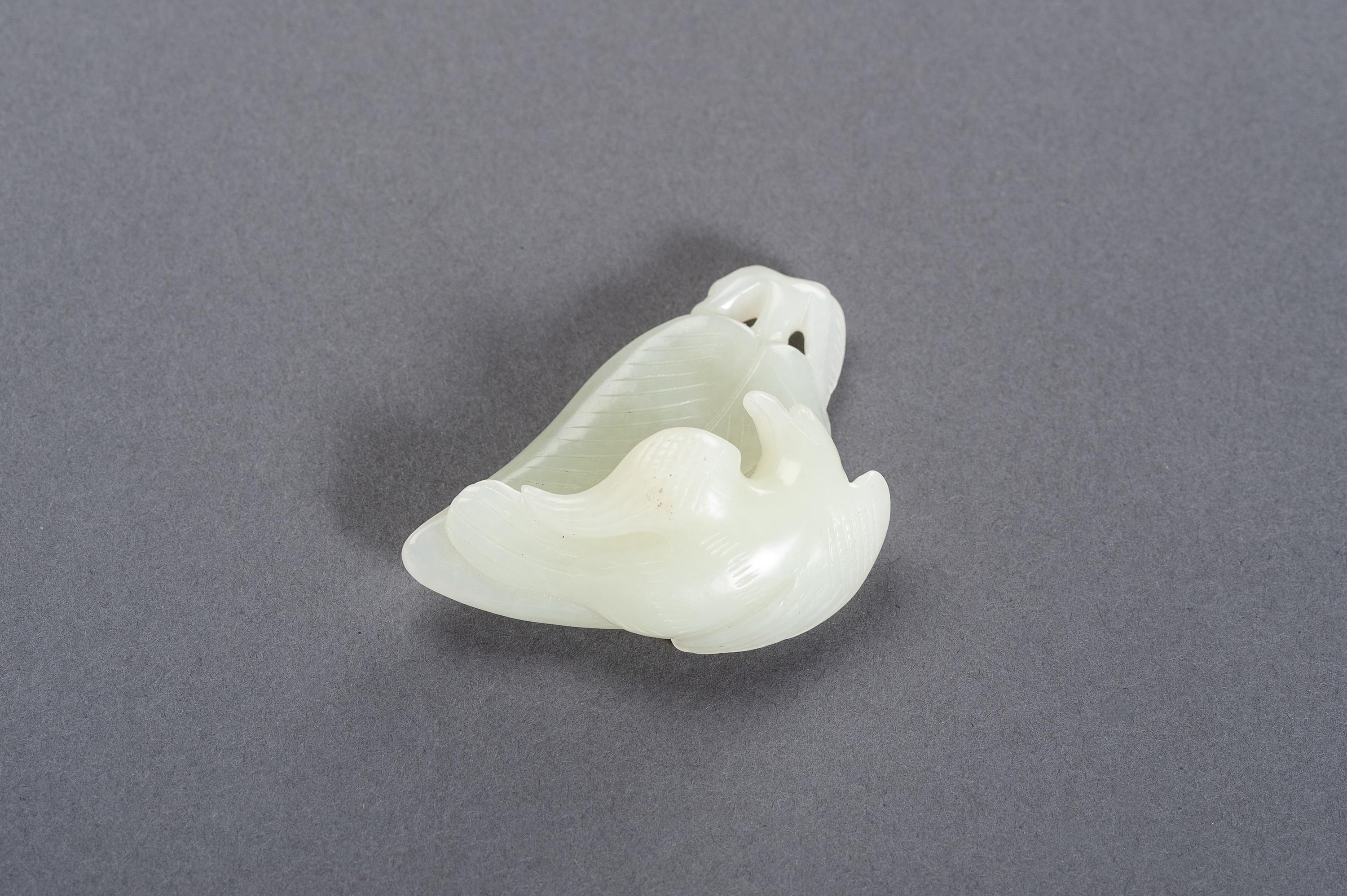 A celadon jade 'Bird of Prey on Leaf' pendant, China, Late Qing Dynasty (1644-1912) to Republic Period (1912-1949)

Carved as a bird of prey with incised wings and sharply curved beak resting on a large leaf, two spaces between the stem and leaf
