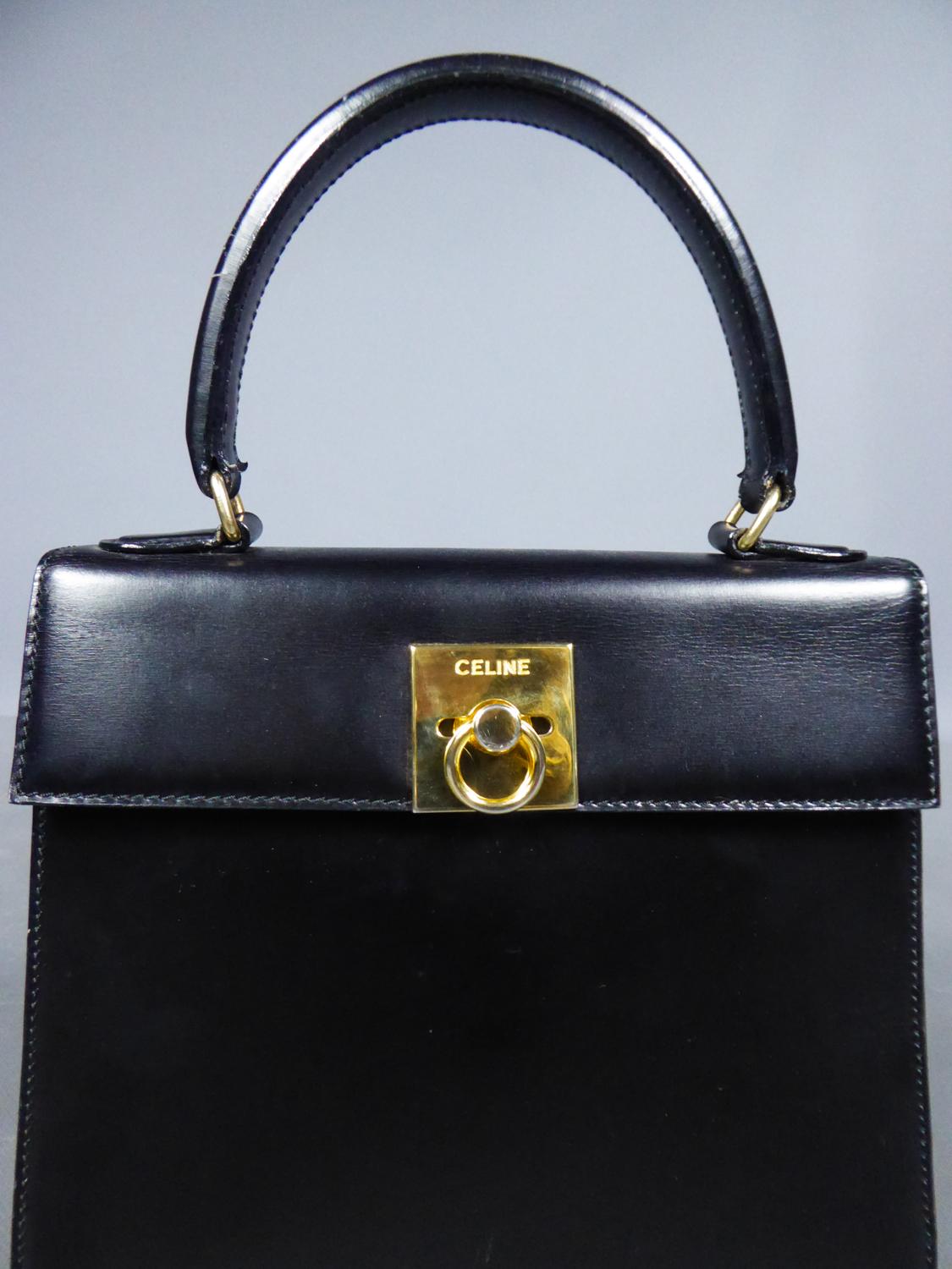 Circa 1995
France

Elegant handbag in black leather with labeled flap from the famous house designer Céline and dating from the late 1990s. Classical refined cut in shalpe of parallelepipoid rectangle. Matching straight handle retained by brass