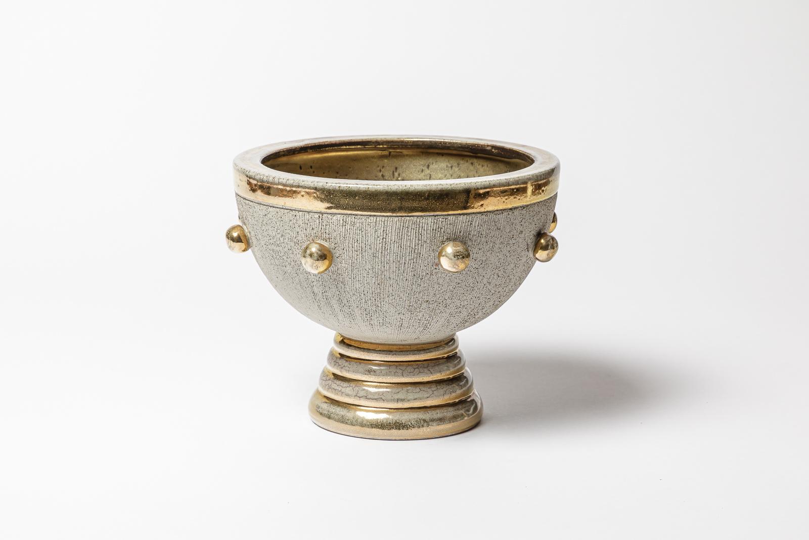 Una tazza in ceramica con decorazioni in bianco, marrone e oro.
Firmato sotto la base 