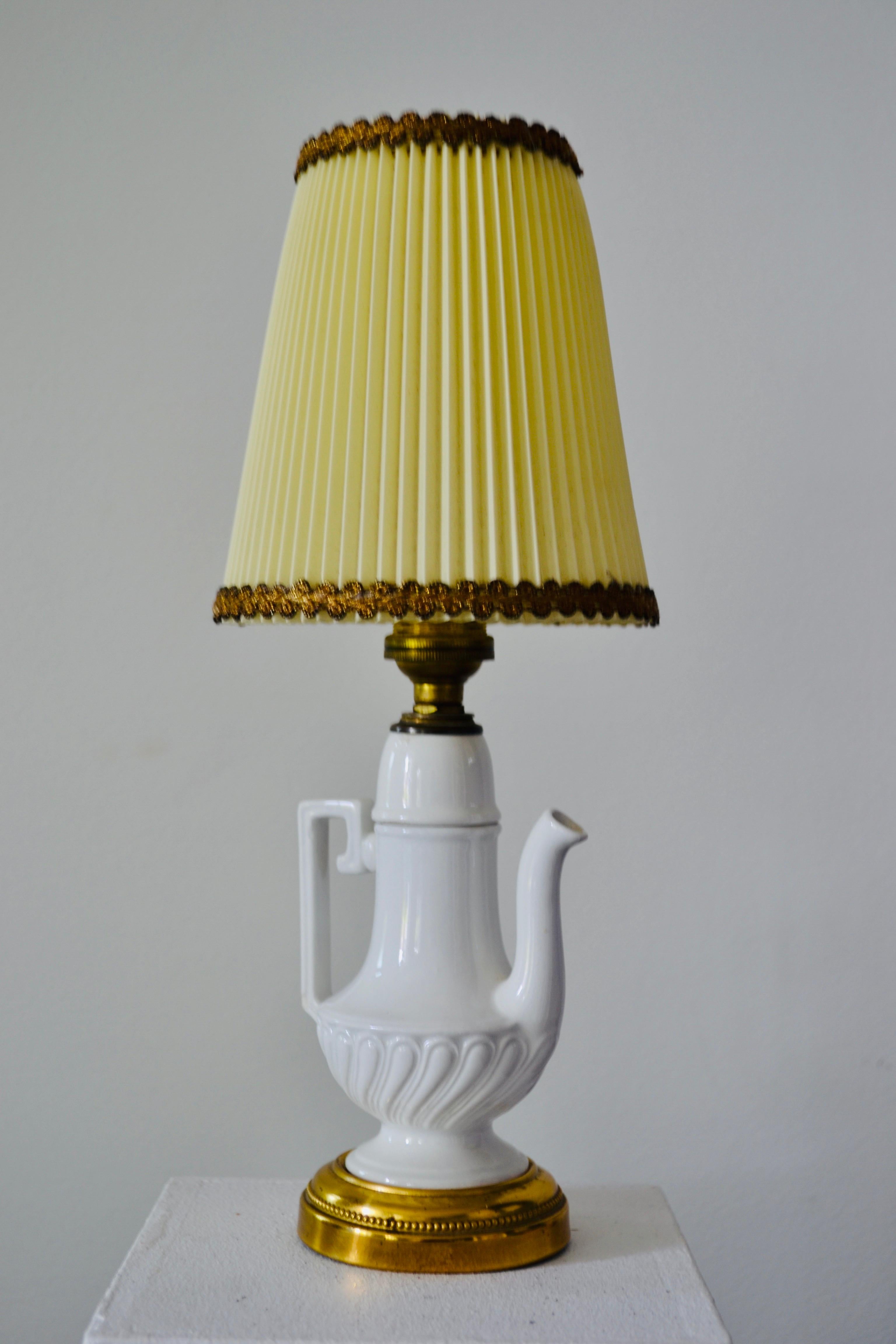 A ceramic lamp with gilded brass accents, in the Napoleon III style, featuring a pitcher with a handle. The lampshade is original, and the piece has a beautiful patina.







