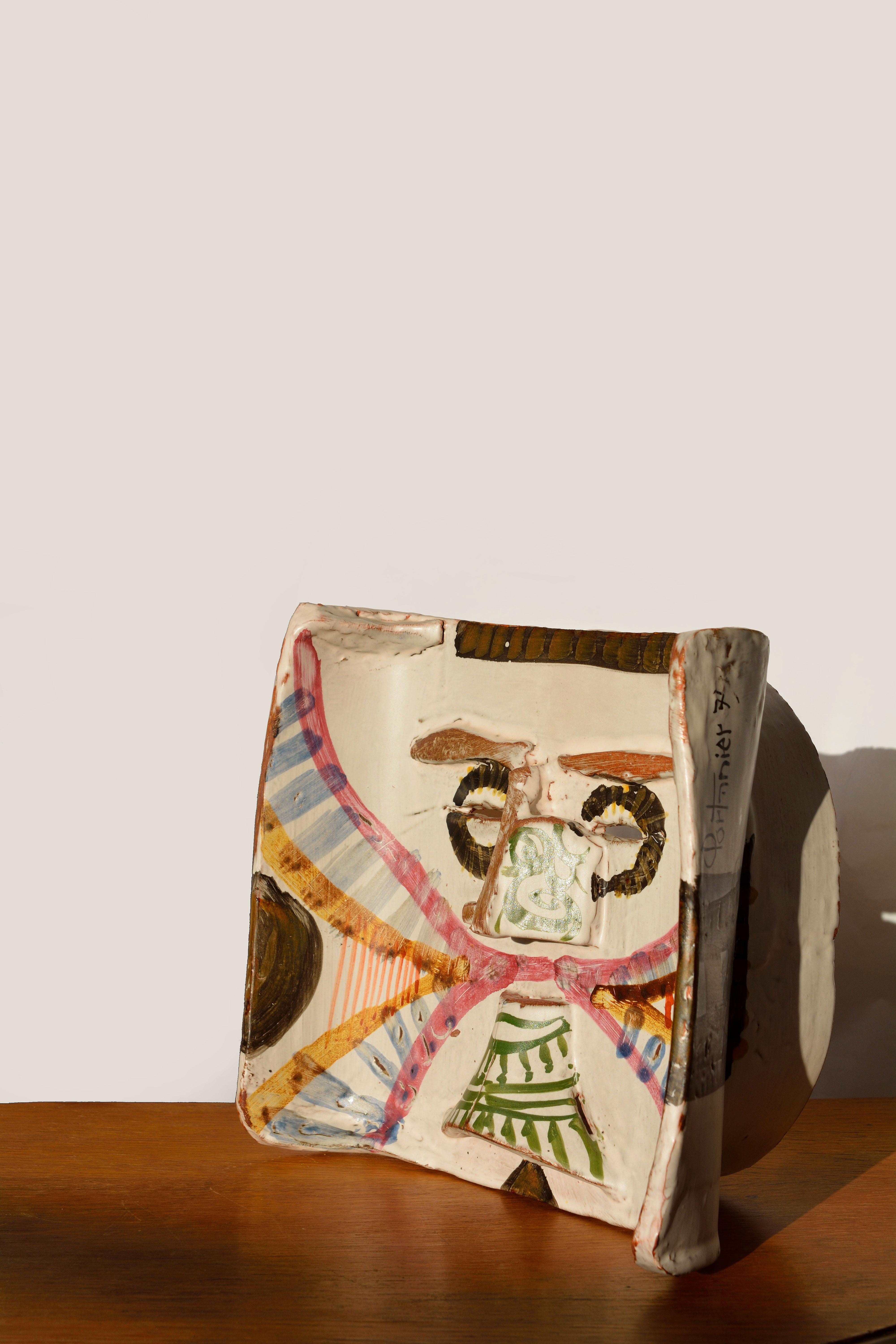 Gilbert Portanier, masque
France, Vallauris, 1979.
Signé
Pièce unique

Masque en céramique émaillée avec un décor polychrome.
Nez, arcades et barbe en relief et deux fentes pour créer les yeux.
   
Mesures : H max 23 cm / 11 in.
L max 26 cm