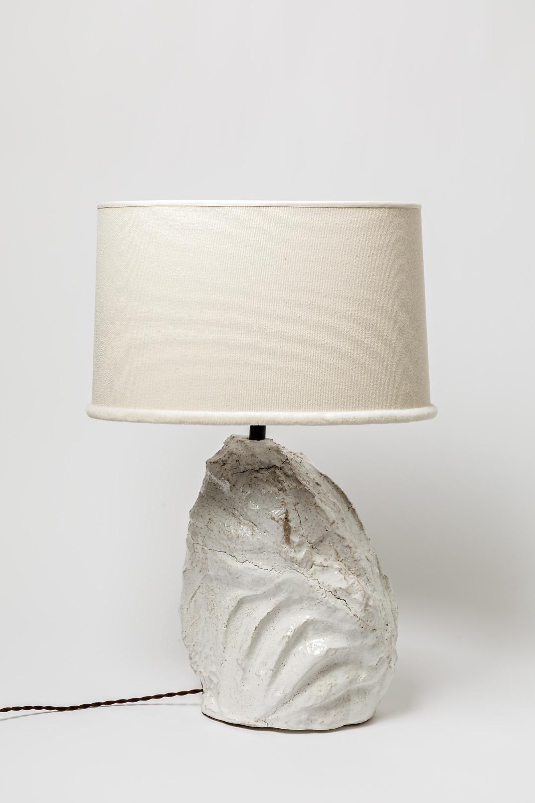 A ceramic table lamp with white glaze decoration.
Sold with a new lampshade and a new European electrical system.
Signed under the base.
Perfect original conditions.
Circa 2022.
It' s possible to have a pair and few pieces.
Dimensions are