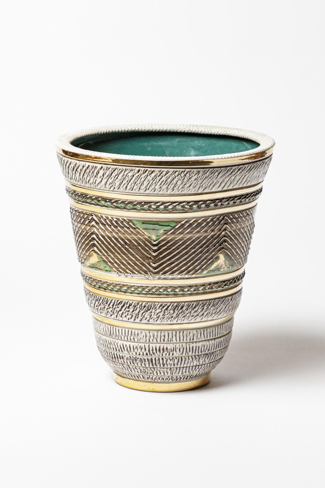 Un vaso in ceramica di colore bianco, verde e marrone,  decorazioni in oro e smalto nero.
Firmato sotto la base 