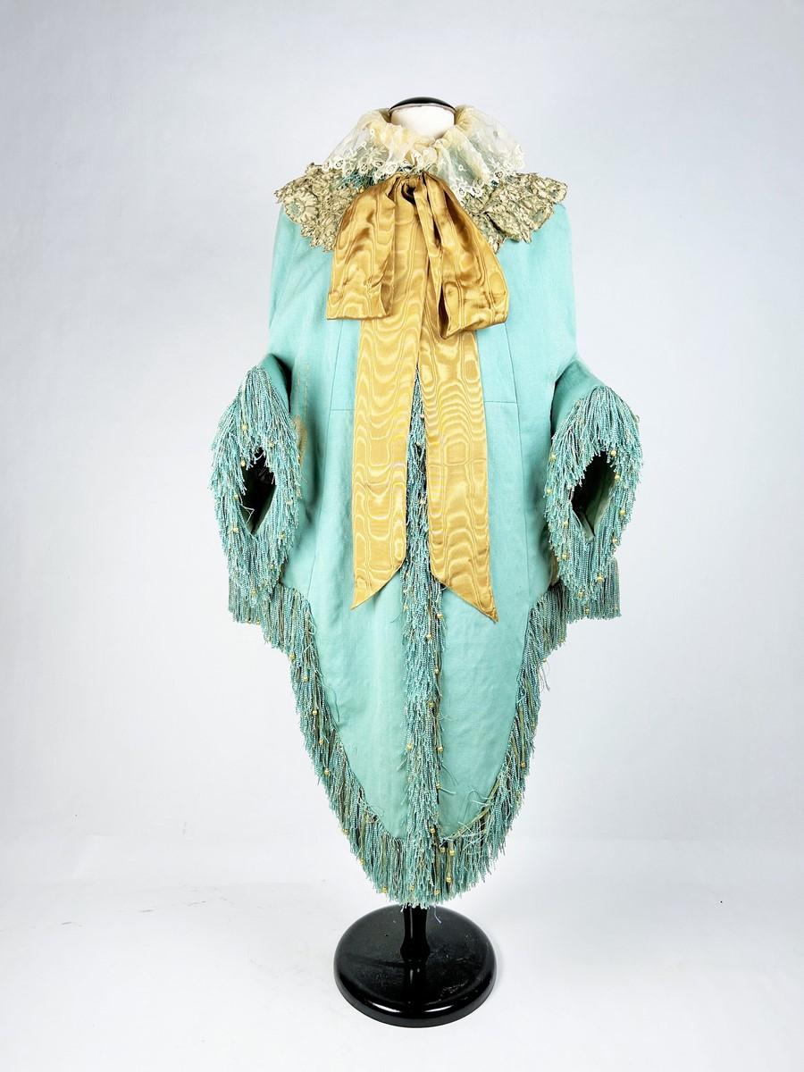 Circa 1875
France
Oriental-style opera or ceremonial visit in gold-spun turquoise silk tapestry known as Abba and originating from Syria. Cut with short basques at the back, long panels at the front, and bent sleeves loaded with color-embossed silk