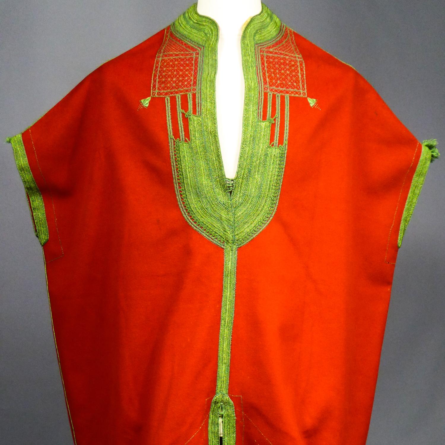 Circa 1900/1920
Tunisia

Spectacular ceremonial tunic in adult size or festive Tunisian Jebba for circumcision dating from the first half of the 20th century. Very fine vermilion red wool felt embroidered with floss-silk with a yellow-green plant