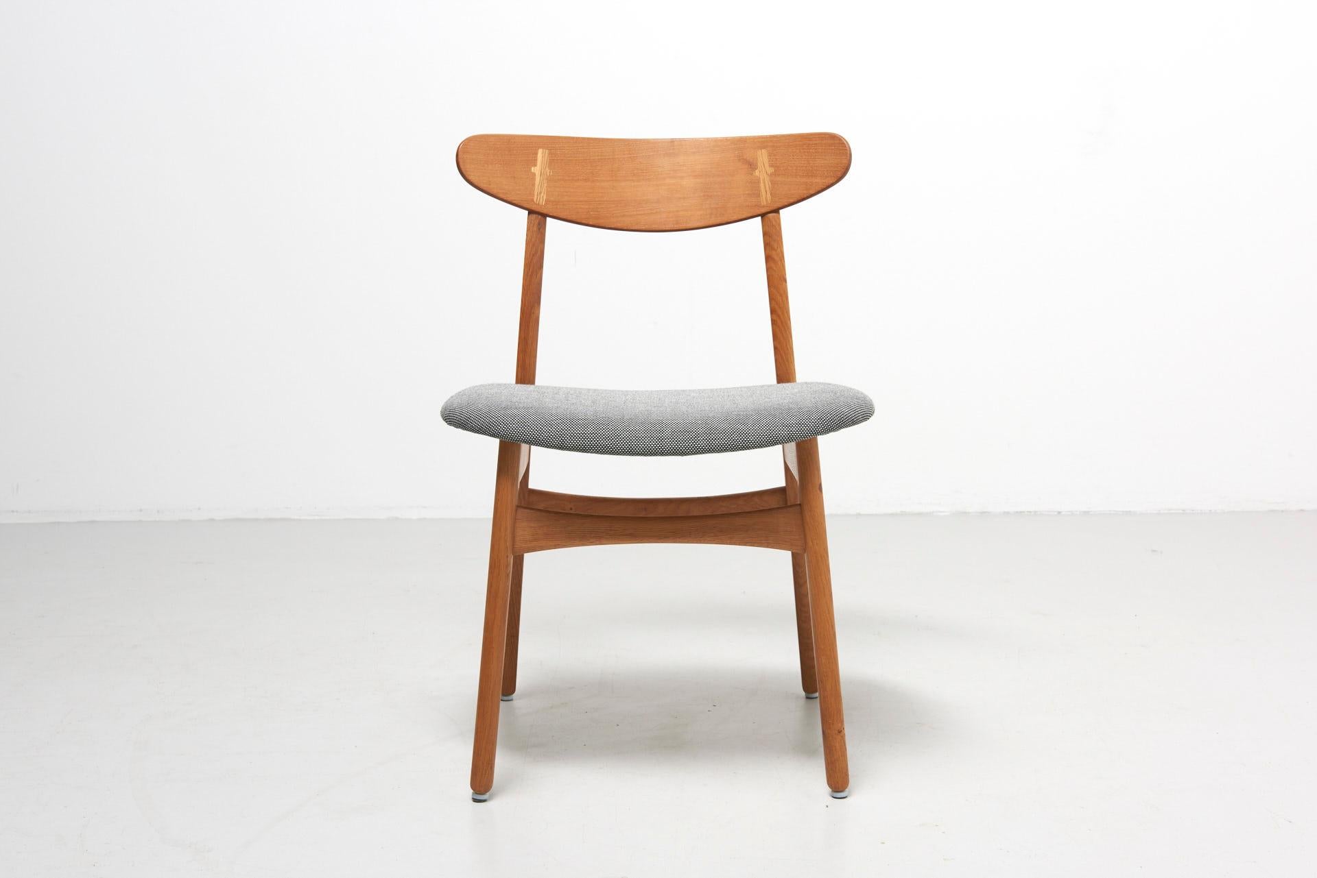 An oak chair with a teak backrest. Design by Hans J. Wegner in 1952. Model CH30, produced by Carl Hansen & Son in Denmark. Reupholstered with Kvadrat fabric.