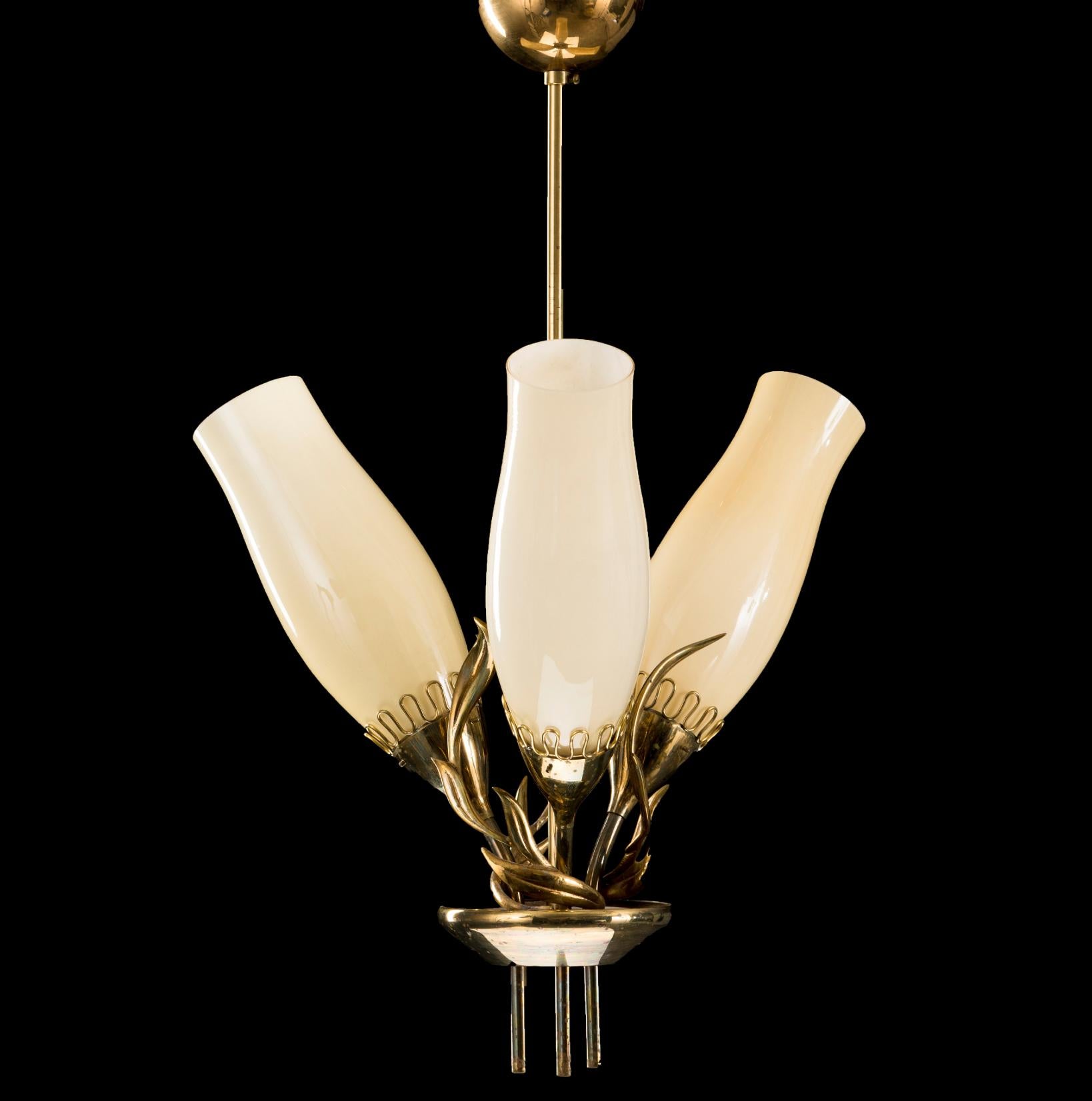 A  chandelier designed by Mauri Almari for Idman Oy, Model 51122. Finland, circa 1950s.
Featured on Idman catalog No 132, page 7.
Polished brass with three original glass shades. Measure: H 27.5