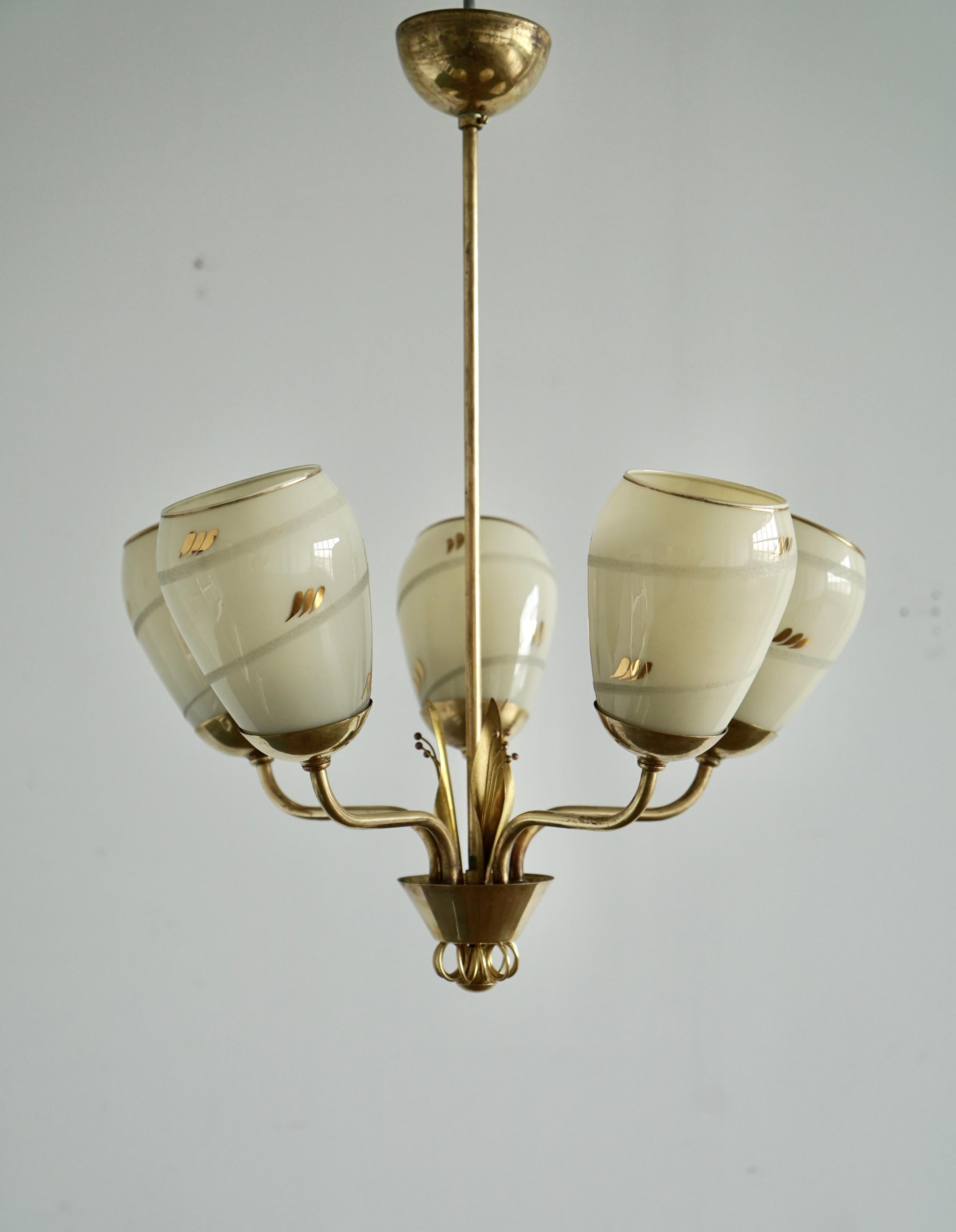 Five lights chandelier design attributed to Paavo Tynell, Produced by Idman Oy, Model 51145. Finland, circa 1950th.
Polished brass with leafs decor and milk glass shades.
Marked “Idman”. Existing wires, rewiring available upon request. Original