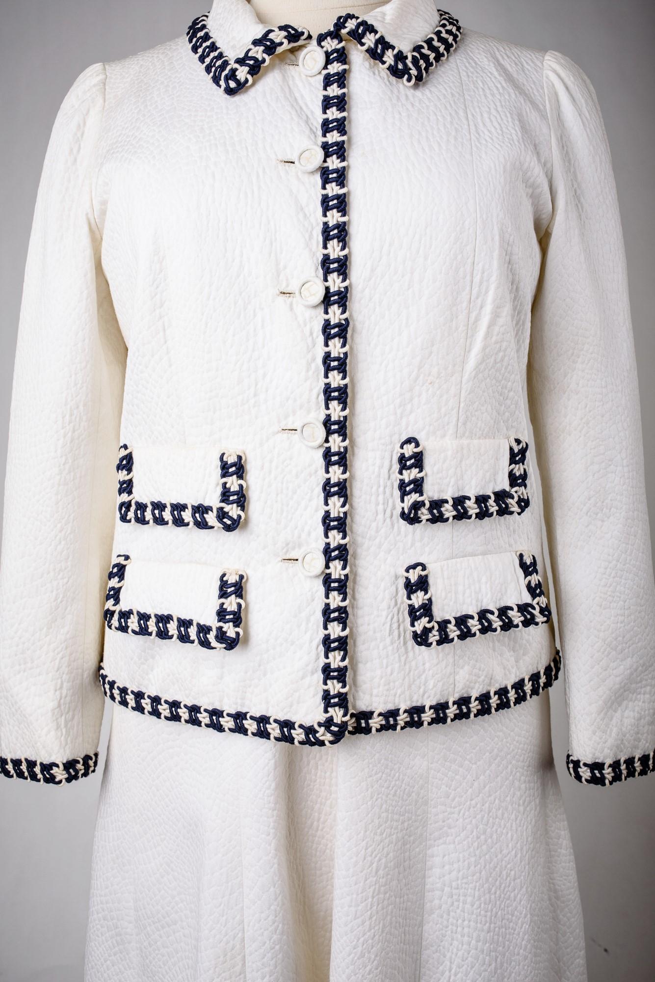 Circa 1970

France

Interesting historical model. Chanel Haute Couture white cotton piqué dress and suit effect jacket numbered 59989 and 59990 and dating from the early 1970s (probably from the time of Mademoiselle!). Sleeveless, V-neckline