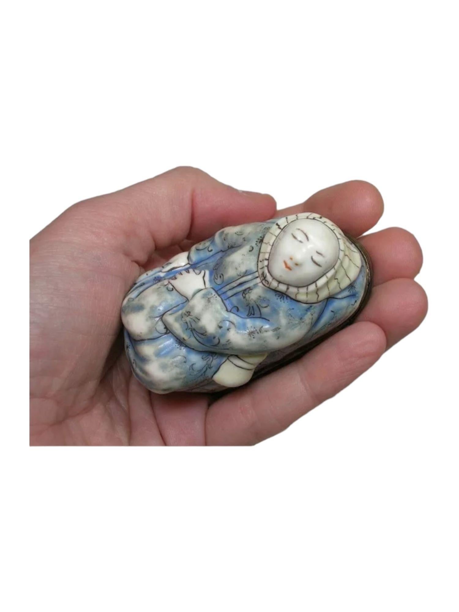 The soft paste porcelain reclining monk in blue robe and striped hood, the cover scene of kakiemon tree trunk and interior cover with two butterflies. A tight closure and French discharge mark on rim.