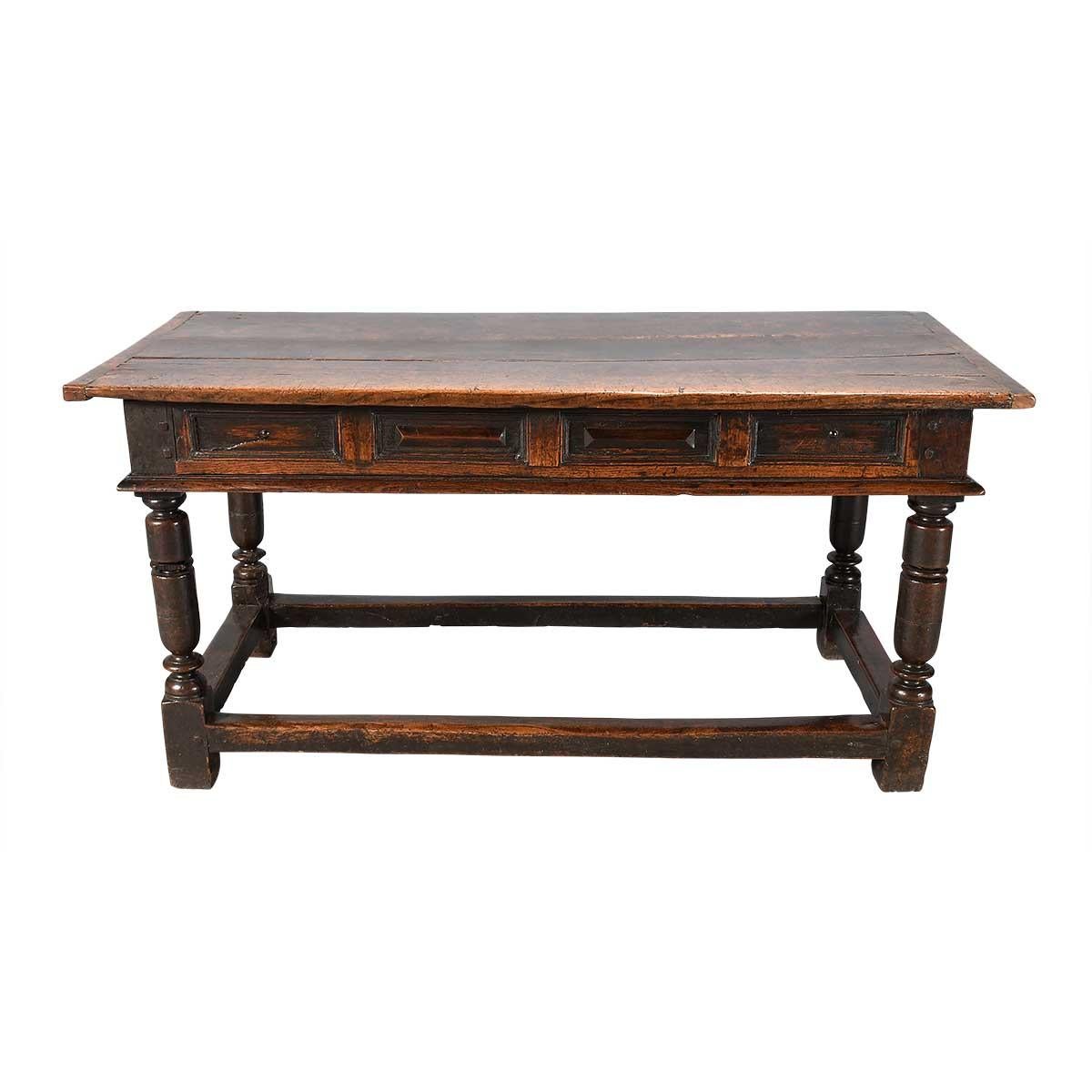 A Charles II period oak side (or serving) table with paneled front rail. The two center panels of this rail have a raised prism-shape at the center while the two end panels have a small dome in the center. These panels are framed by molded rails.