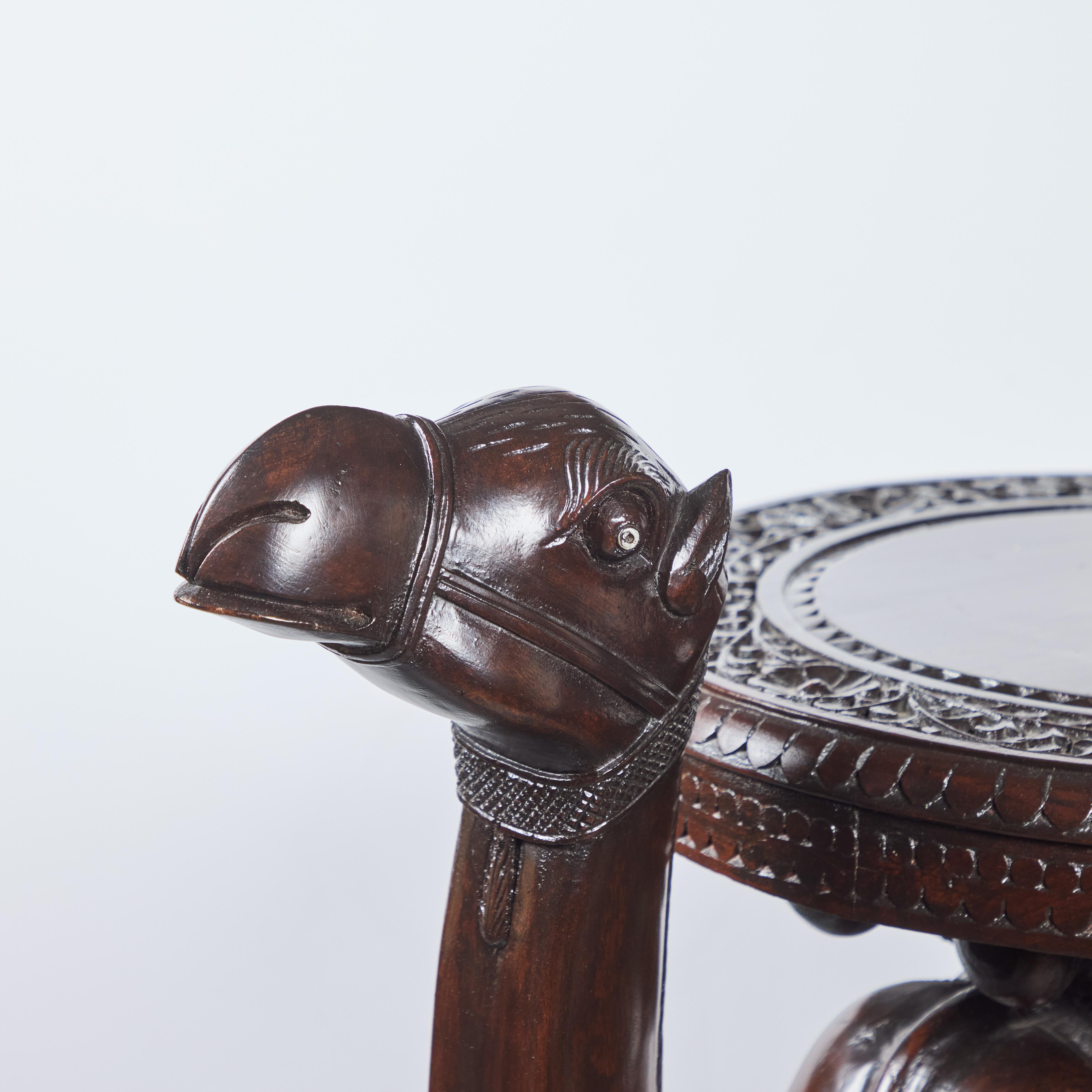 A charming solid wood,  hand-carved wooden camel table with elaborate detail.  Table top:  29”H x 17.5”Diameter