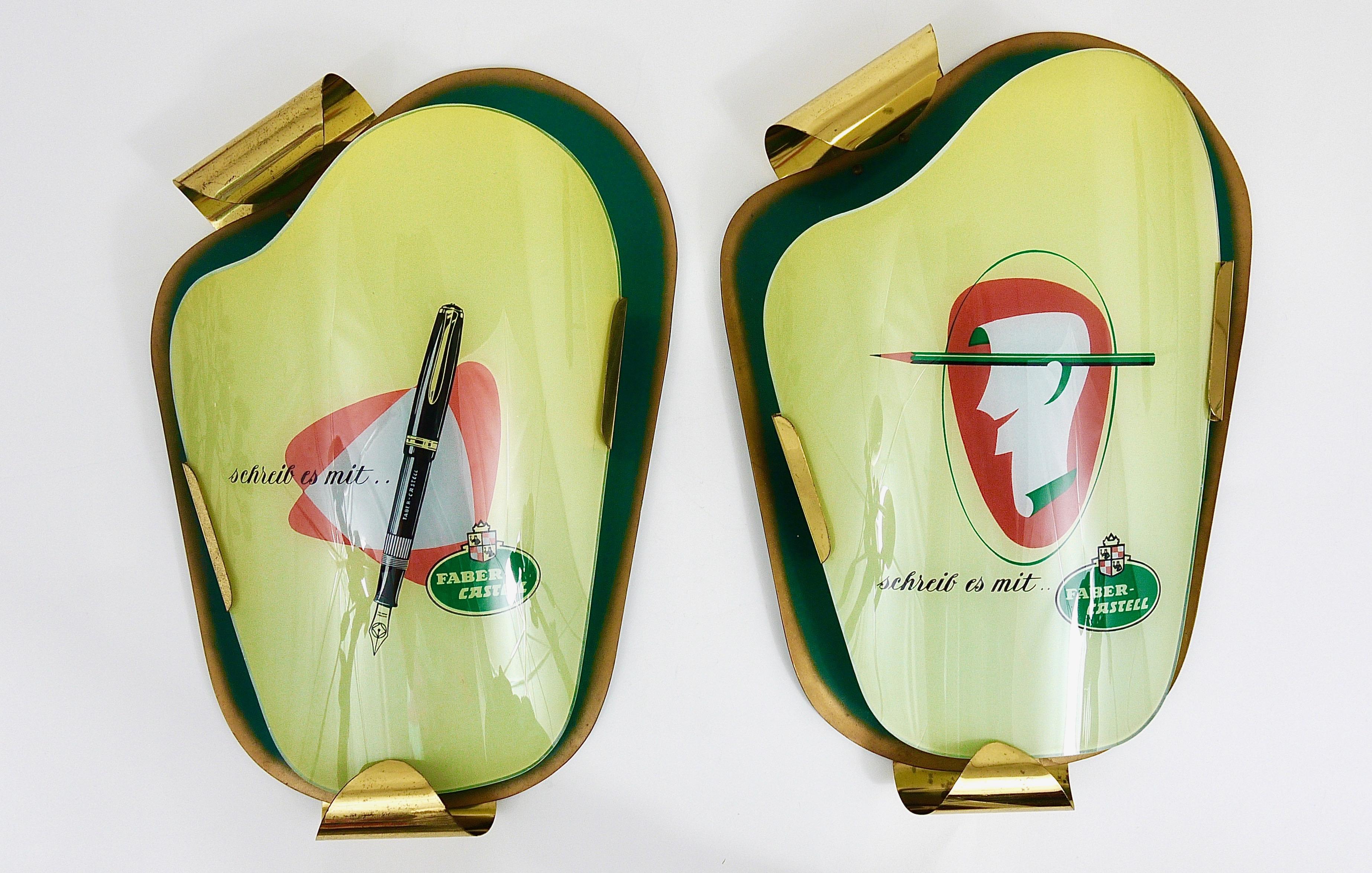 A beautiful asymmetrical midcentury advertising wall light for Faber-Castell fountain pens. A charming piece from the 1950s, made of brass and green lacquered metal and a front made of real glass. This advertising sign is in very good condition with