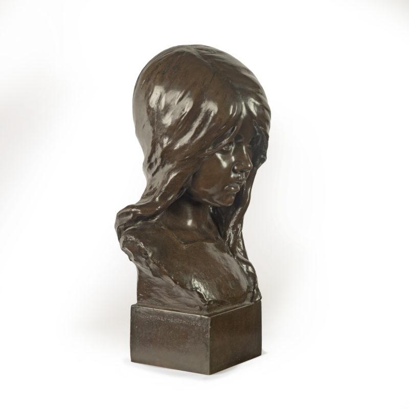 Charmant buste d'enfant par Edwin Whitney-Smith, daté de 1910, la fillette a la tête légèrement inclinée vers l'avant alors qu'elle regarde sous une mèche de cheveux, monté sur un bloc carré signé au verso 'E Whitney-Smith 1910'.

Ce bronze est une