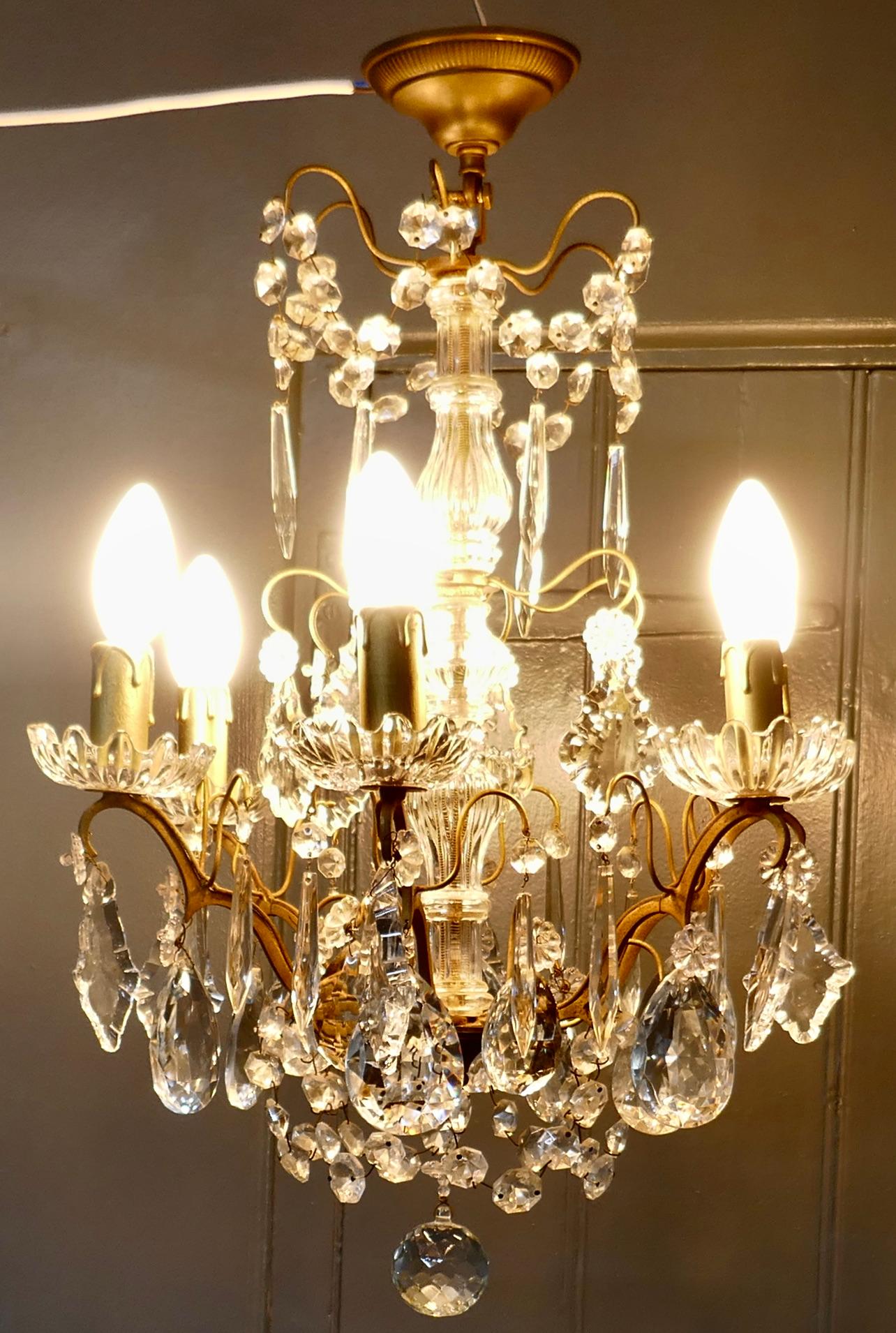 A Charming French Crystal 6 Branch Brass Chandelier

This is a superb brass chandelier, the brass has a gilded finish and the 6 arms have glass sconces which are hung with crystal chains, drops and pendants, in a variety of pretty shapes 

 The
