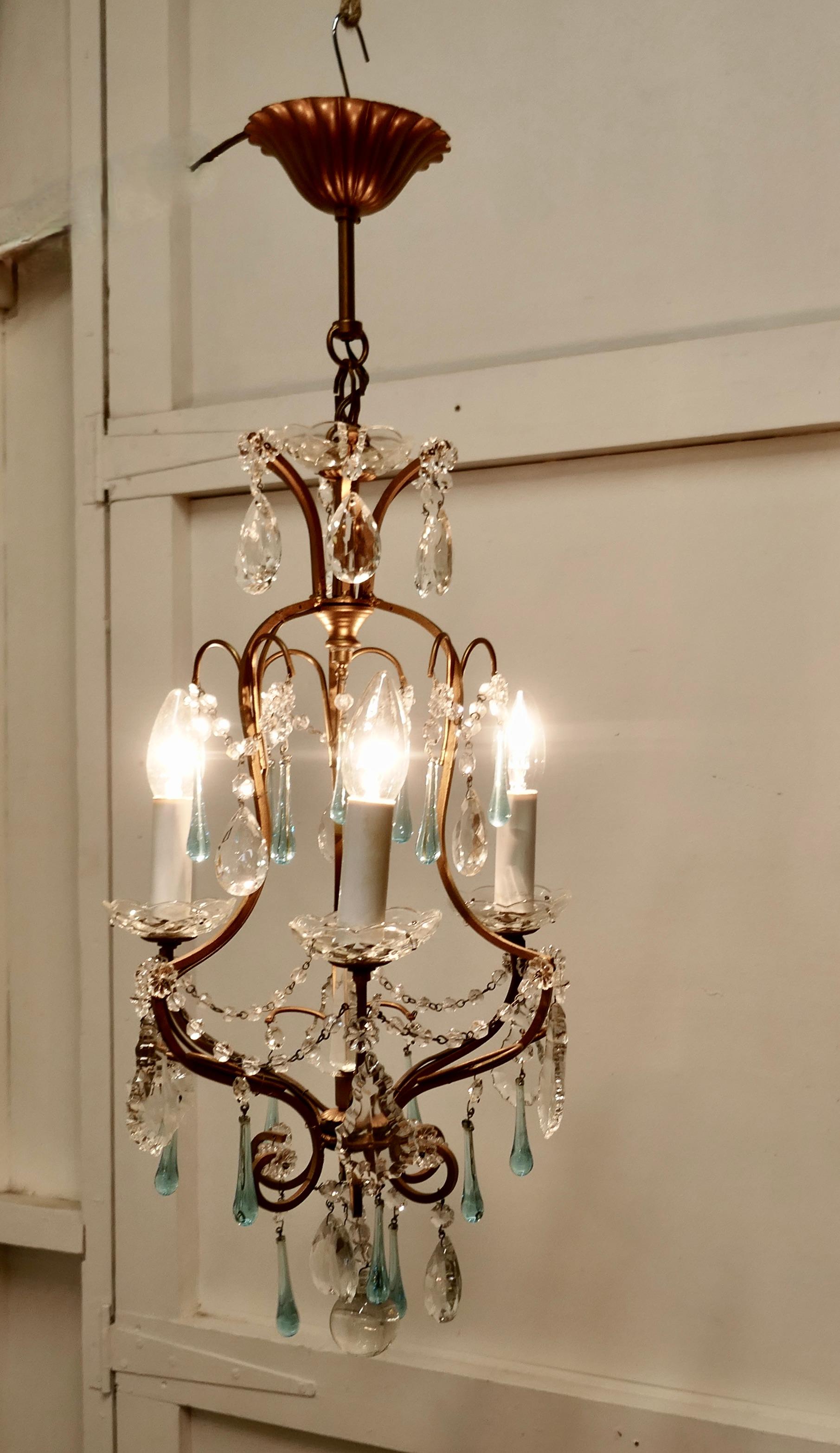 A charming French turquoise crystal and brass chandelier.

This is a very pretty and dainty piece, the brass has a gilded finish and 3 arms, the light is hung with beautiful Turquoise tear drops, crystal pendants. 

The light is in good working