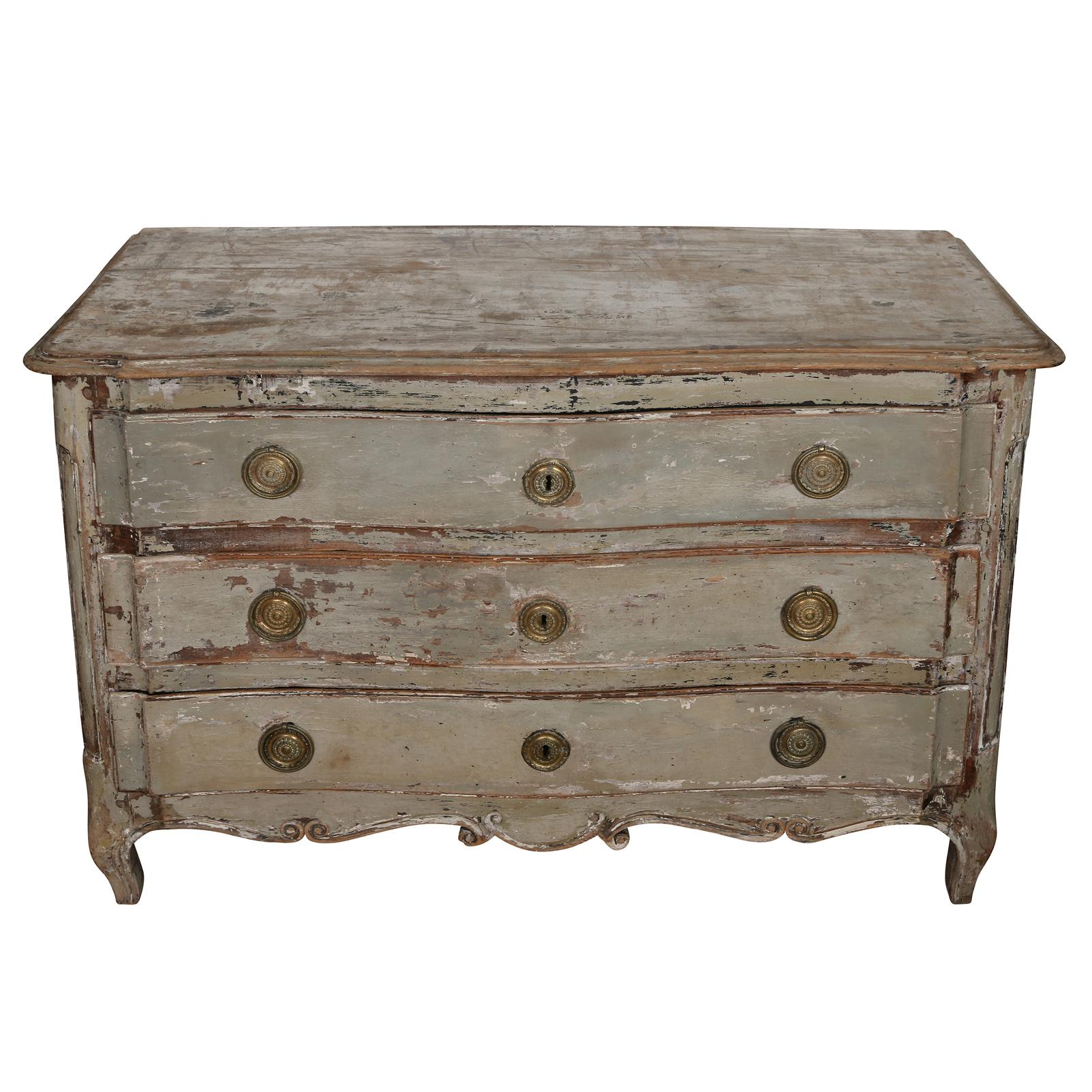We love this Louis XV style commode for its soft blue/grey finish and the soft patina it has developed over time.  This elegant piece has three generous raised  panel drawers with original bronze pulls and lovely floral shaped escutcheons. The top