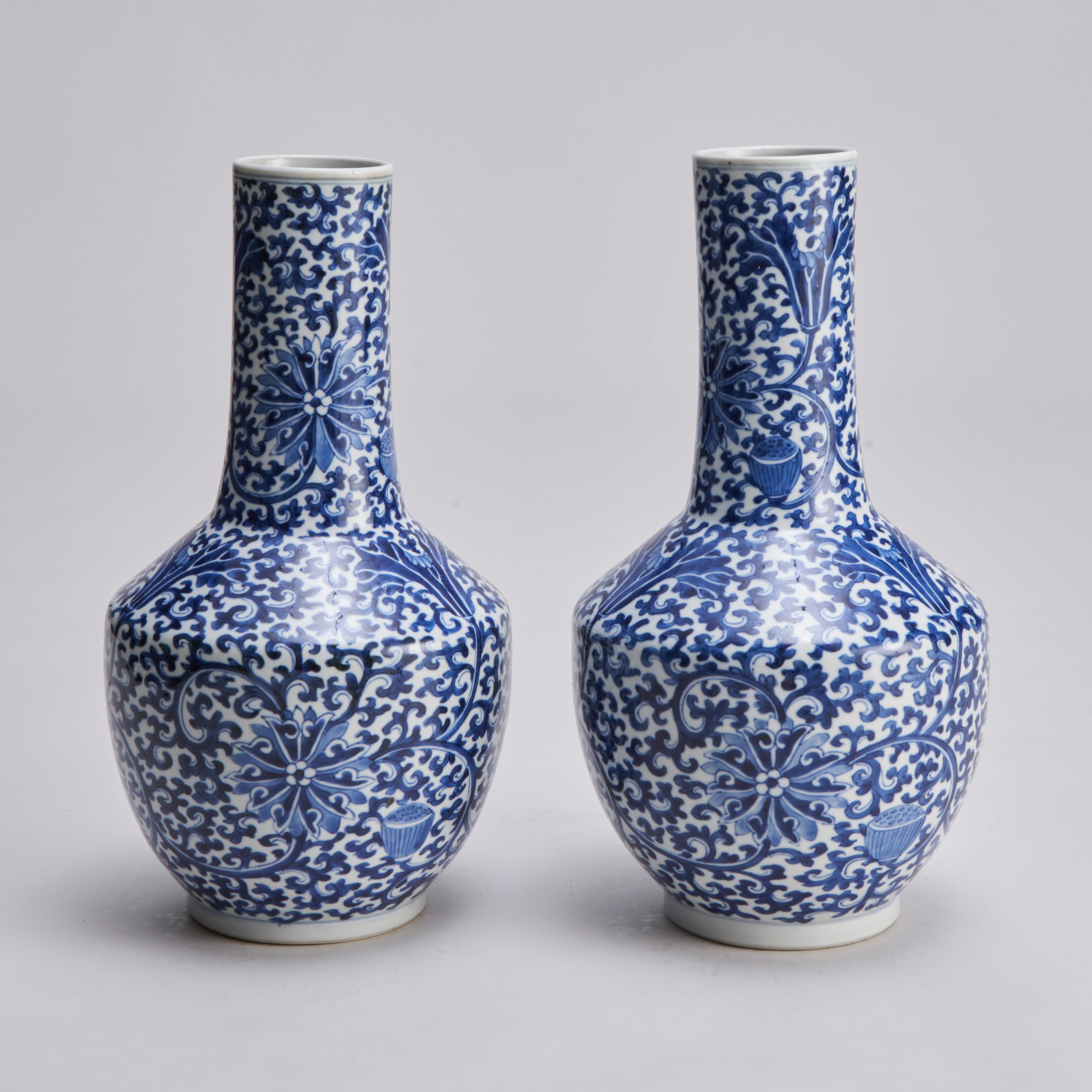 A pair of 19th century Chinese blue and white mallet shaped vase (Yaolingzun) with a dark blue glaze design of stylised lotus flowers and swirling foliage.