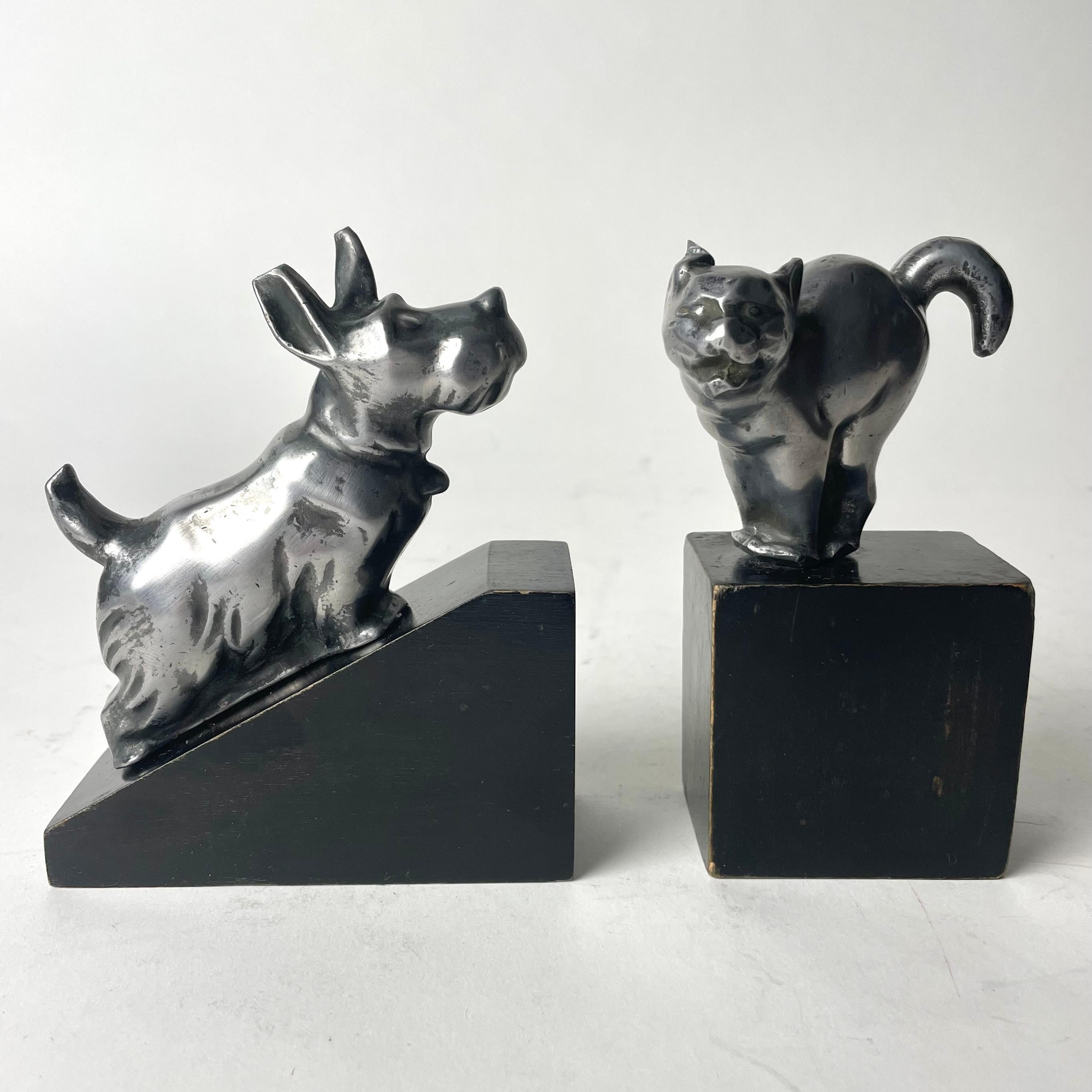A charming pair of Art Deco Bookends with a dog and a cat from the 1920s-1930s. The animals are made in pewter and the base in black lacquered birch. Probably made in Sweden.

One of the cat’s ears with minor damage ( see photo)

Wear consistent