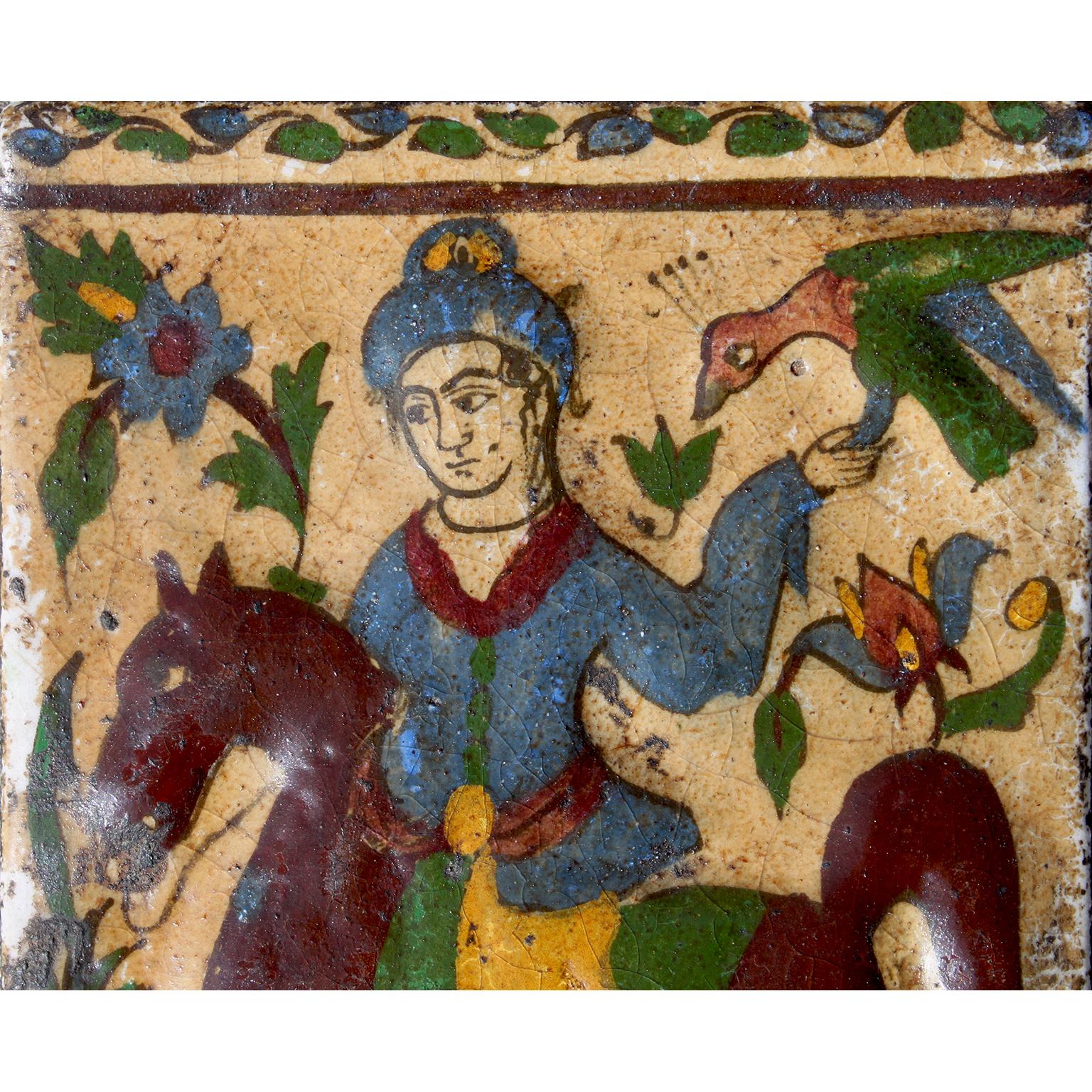 Charmant carreau en poterie moulée à glaçure Qajar, représentant un fauconnier ou Bazdar à cheval tenant un faucon parmi des fleurs et des feuilles, sur un fond jaune, Téhéran, Perse du Nord. Âge réel inconnu, mais probablement entre 1880 et