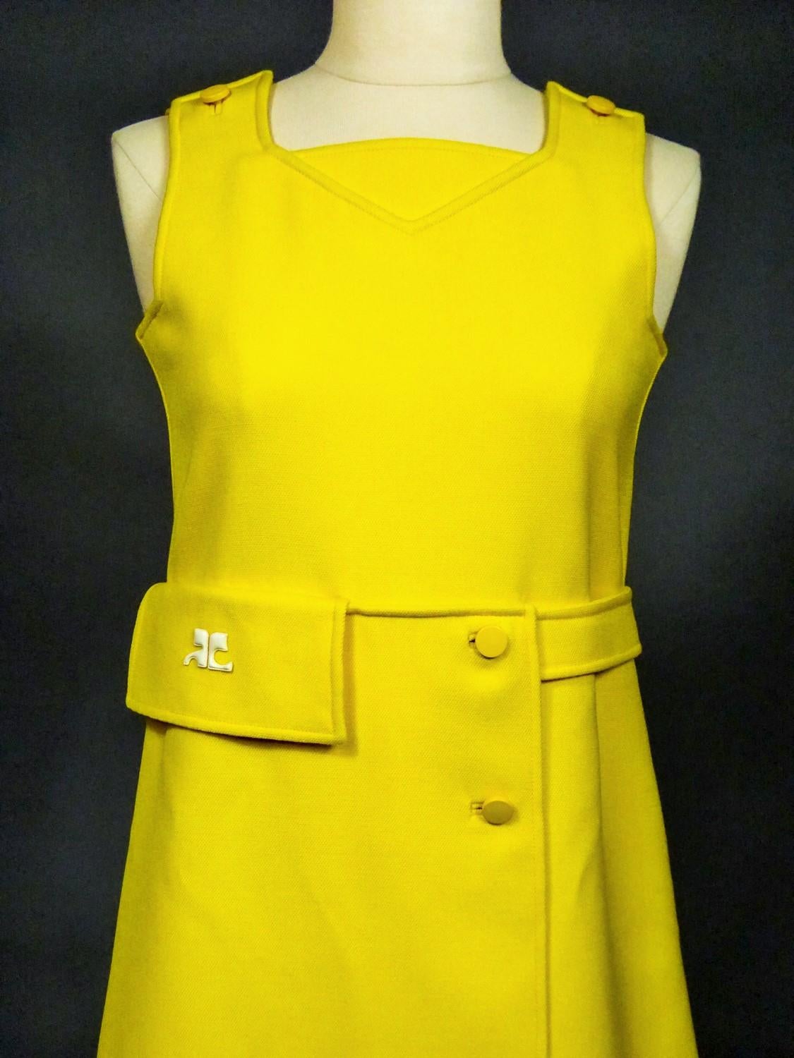 Circa 1968
France

André Courrèges Haute Couture mini dress in thick chick yellow jersey numbered 102322 and dating from the late 1960s. Thick cotton polyamide twill jersey frequently used in Haute Couture. High waist chasuble cut, sleeveless with