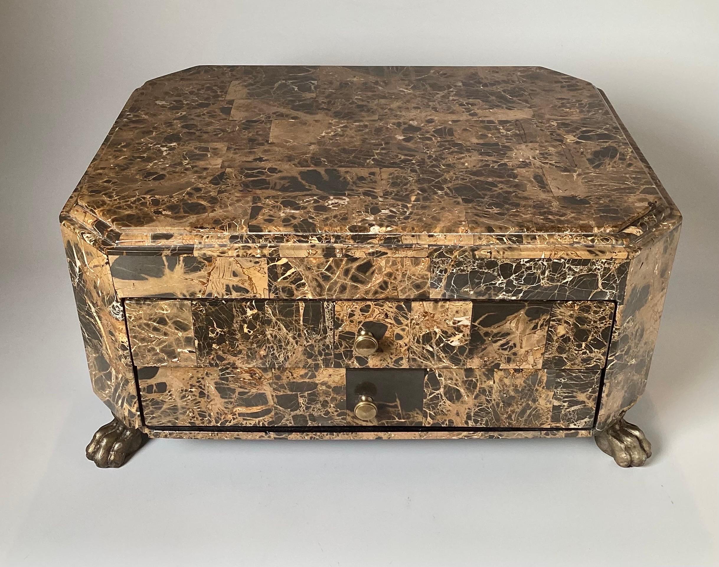 A Chic neoclassical hardstone table box with two drawers, The variegated brown, white and gray stone box with two front drawers resting on brass paw feet.
