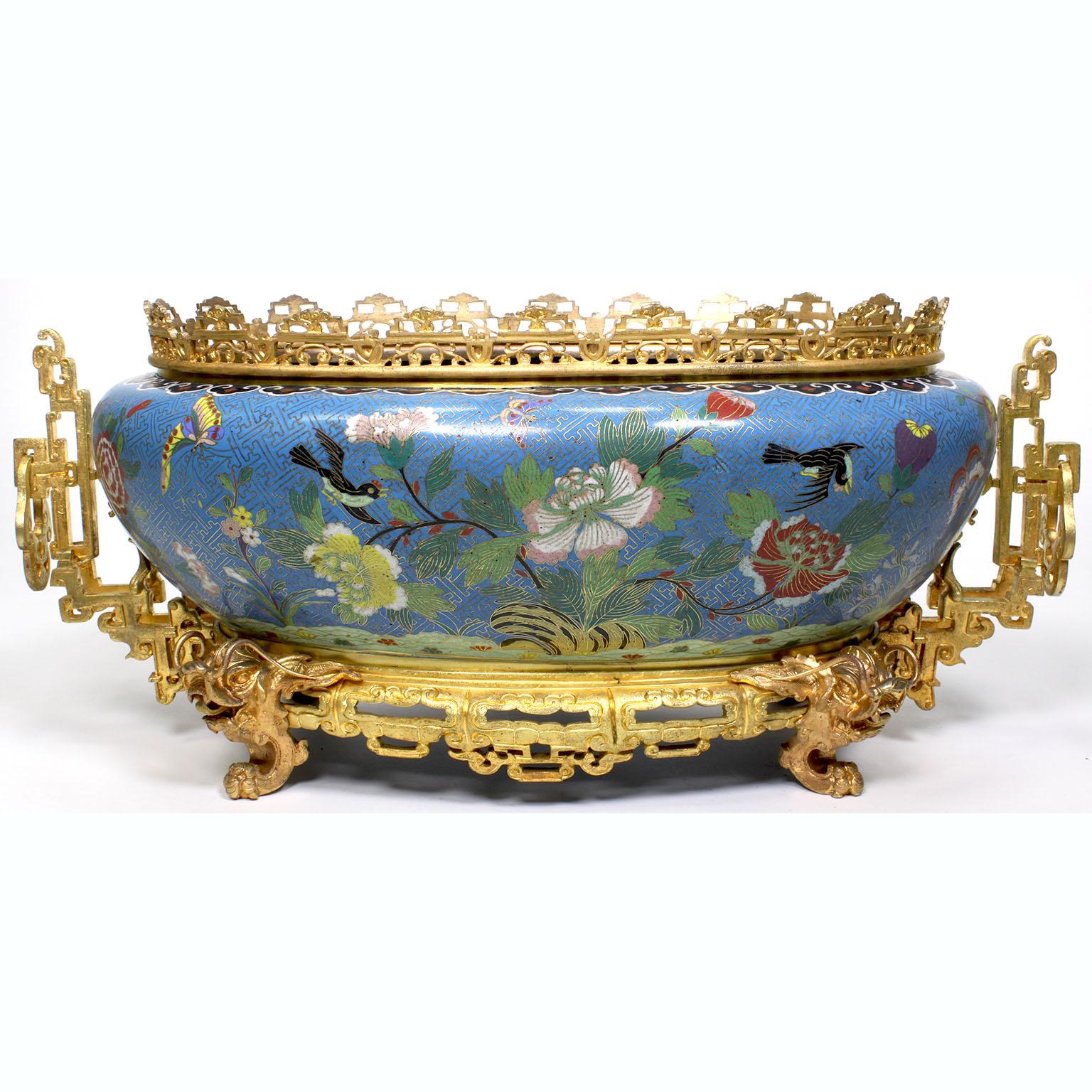 A fine Chinese 19th-20th century gilt bronze mounted cloisonné jardinière (planter). The beautifully and finely executed late Qing dynasty ovoid body cloisonné enamel jardiniere with a blue-Celeste background and colorful enameled depictions of