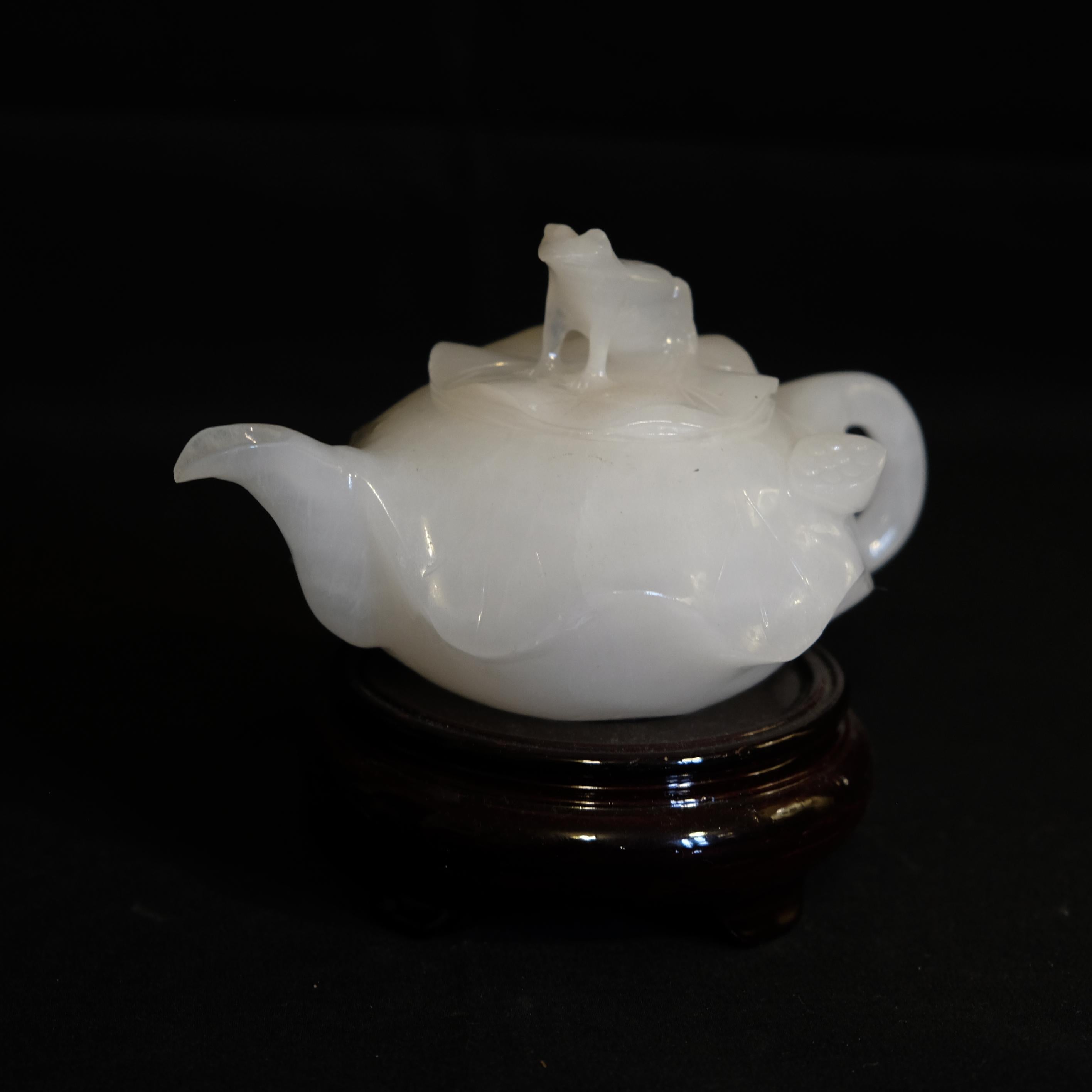 Chinese antique Pakistan jade teapot with wood stand. An unusual waved carving on the entire teapot, the lid with an animal finial on the top.