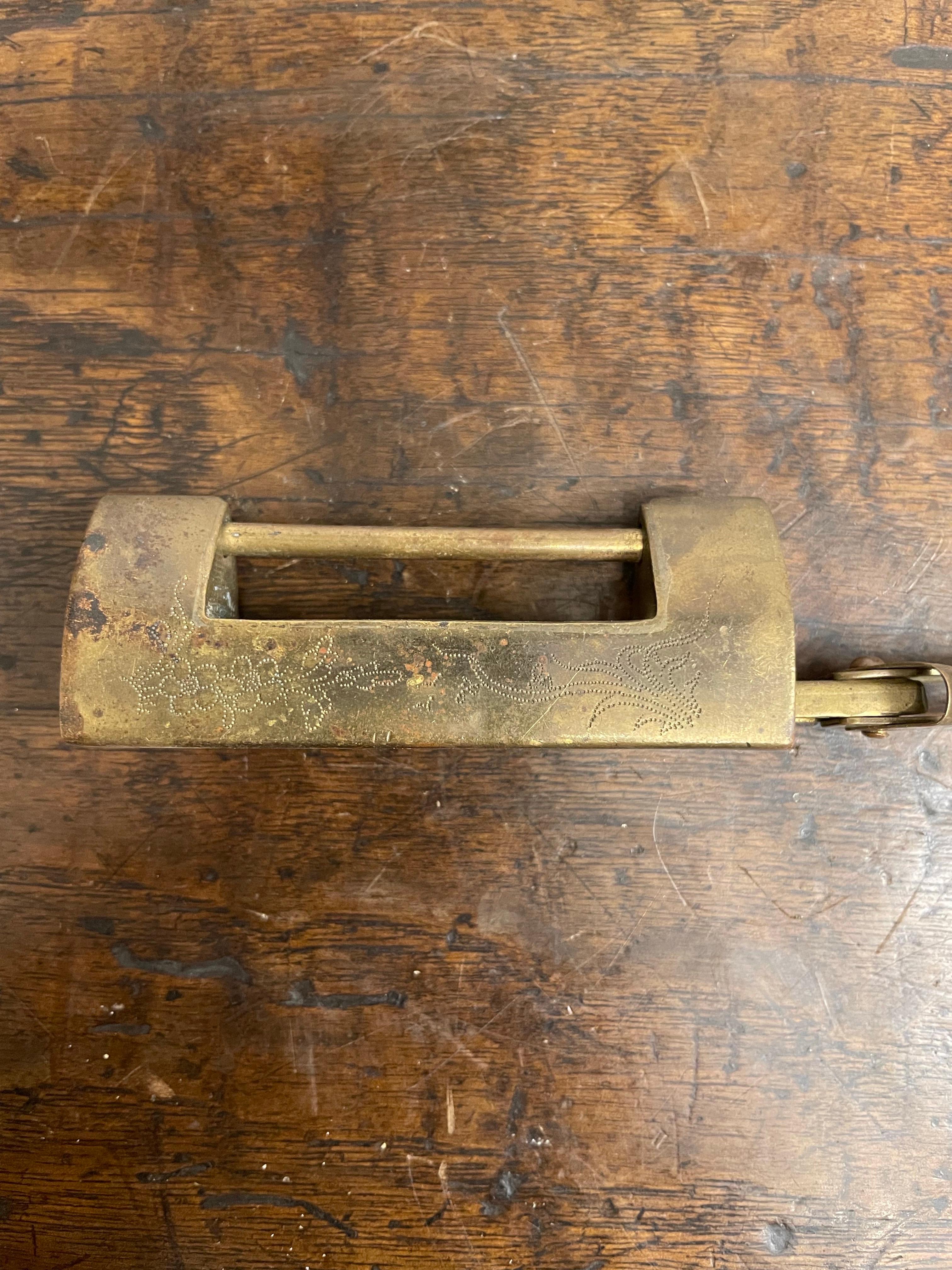 A Chinese Brass Etched Lock with Key, Early 20th Century

Provenance: Private Australian Collection.

Dimension: Height: 2.5cm Width: 10cm Depth: 2cm.