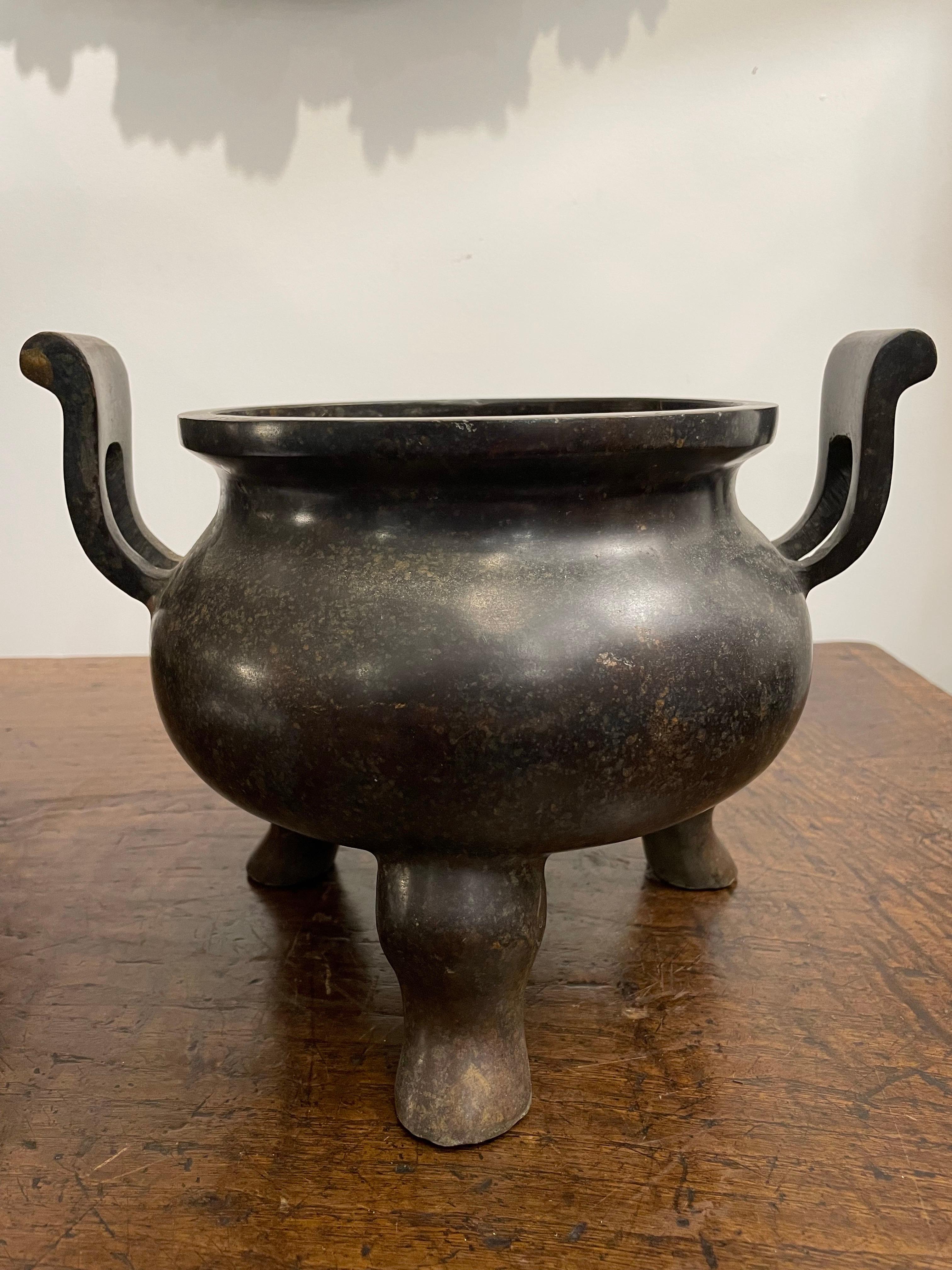 Un incensiere cinese a treppiede in bronzo con manici con marchio Ming Xuande, XIX secolo
Decorazioni per la casa, design d'interni e oggetti da collezione.

Provenienza: Collezione privata di Sydney.

Dimensioni:
Altezza: 22 cm
Larghezza: 29