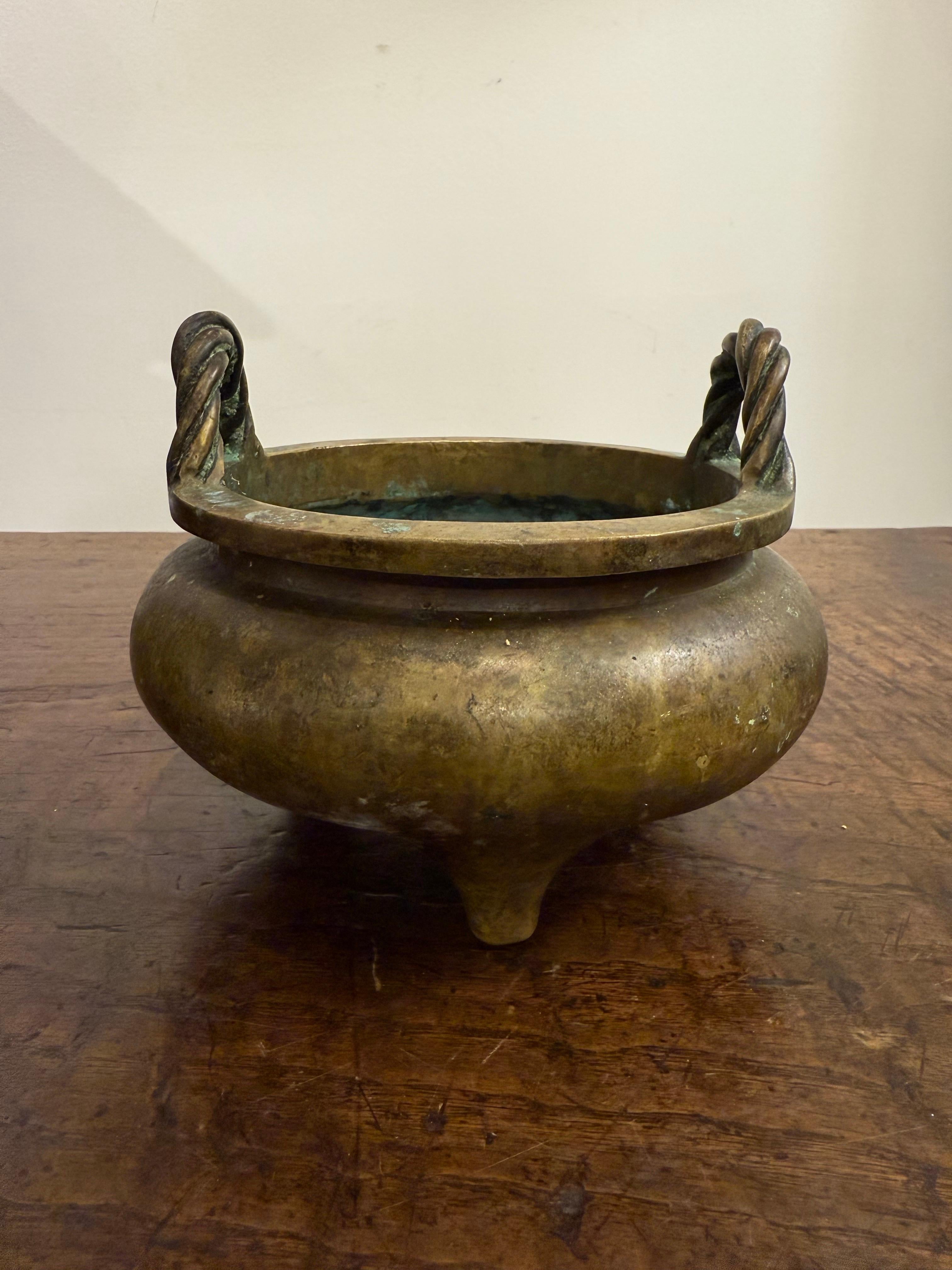 Incensiere tripode cinese in bronzo con marchio, XIX secolo
Con manici intrecciati.

Provenienza: Collezione privata australiana.

Dimensioni:
Altezza: 14 cm.
Diametro: 19 cm.