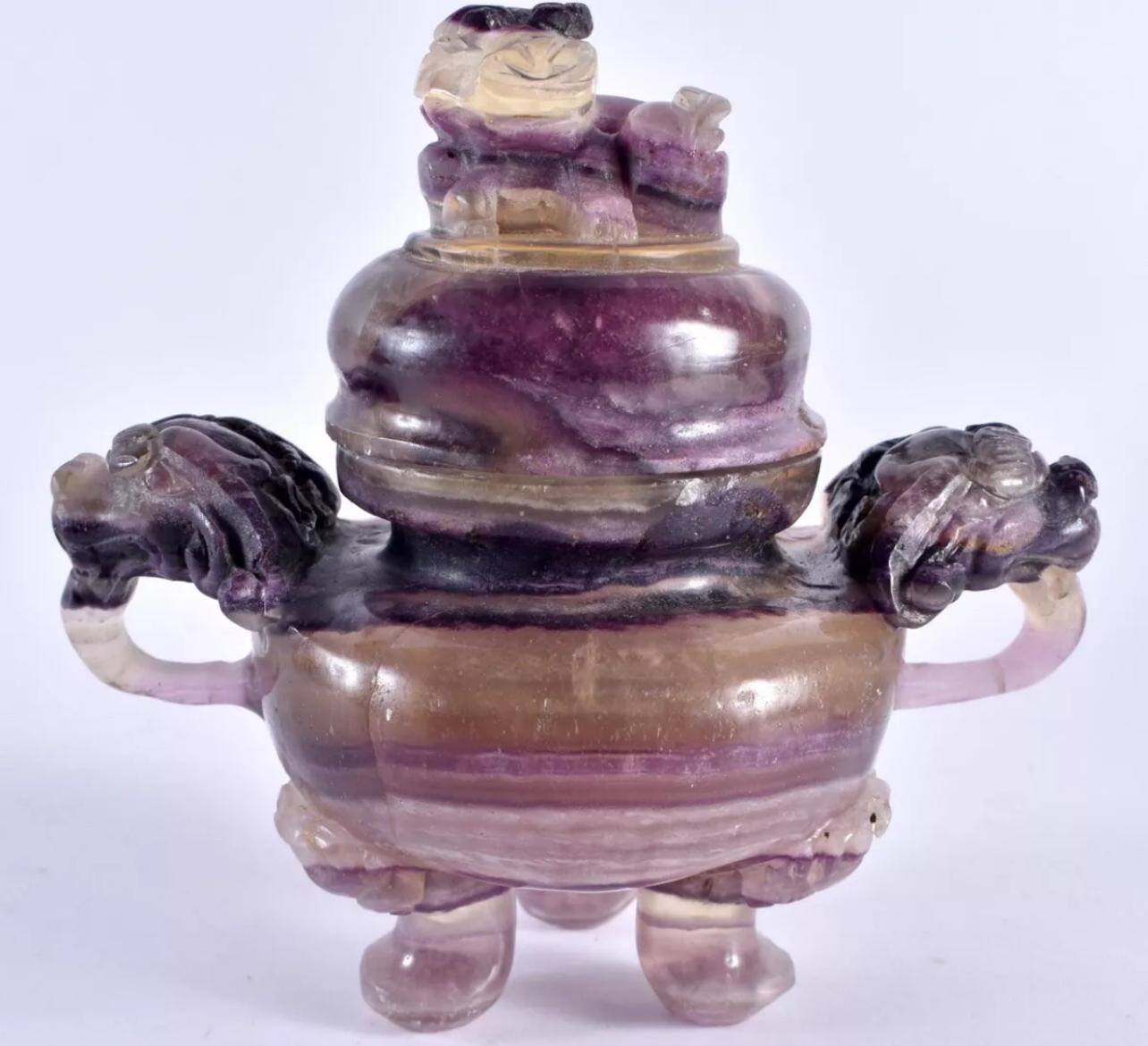
A Chinese amethyst carved censor and cover, 

Qing Dynasty, 19th century.


the rounded body carved with a pair of dragon mask handles, raised on three paw feet, the domed cover surmounted by a Buddhist lion.

A very unique scholar object for