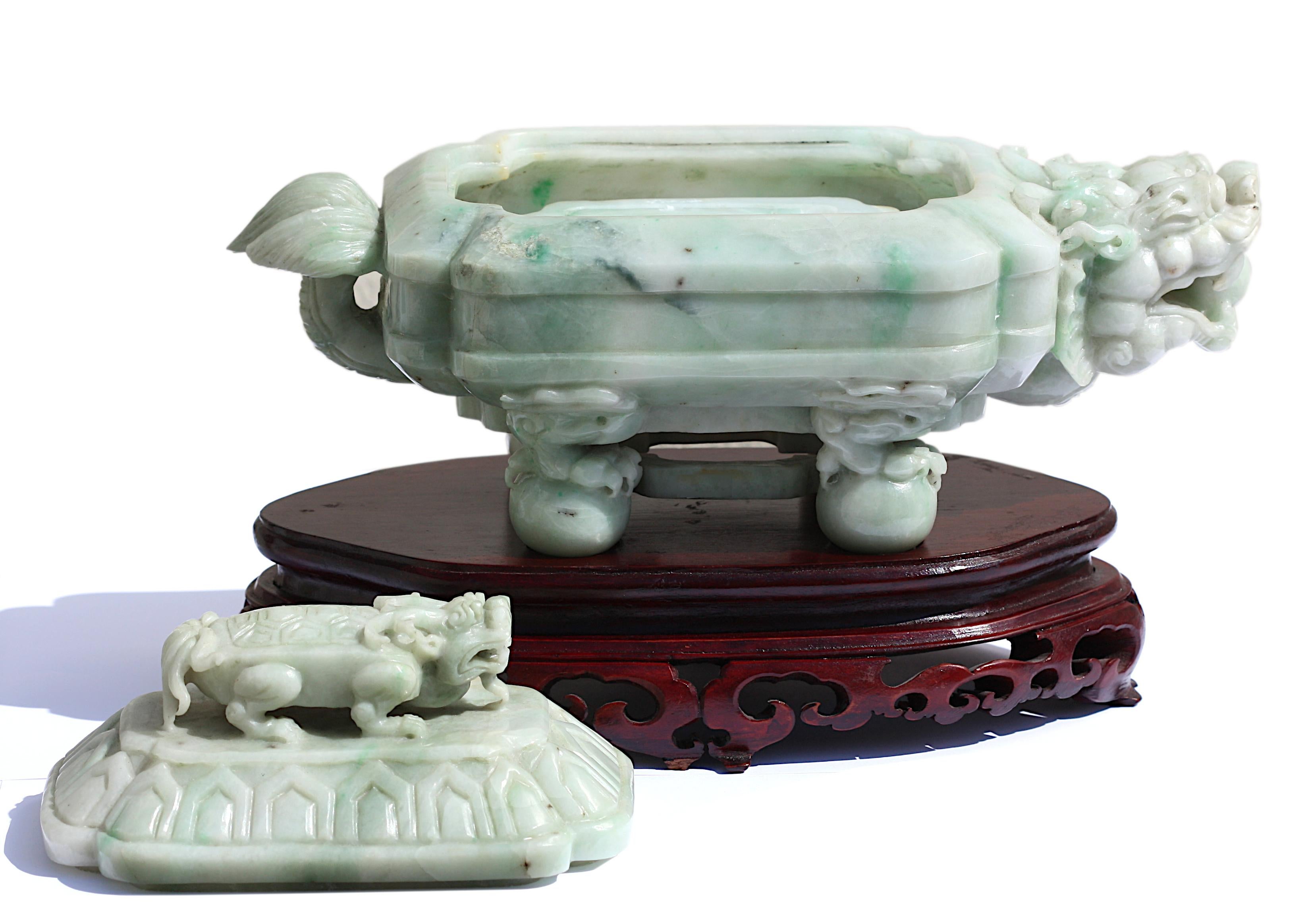 A Chinese Carved Jade Box and Cover, carved in the form of a horned mythical tortoise standing on four balls, the cover with a small tortoise and opening to reveal an ink-stone, the softly polished stone is of a pale lavendar-white color.
8 in. (20