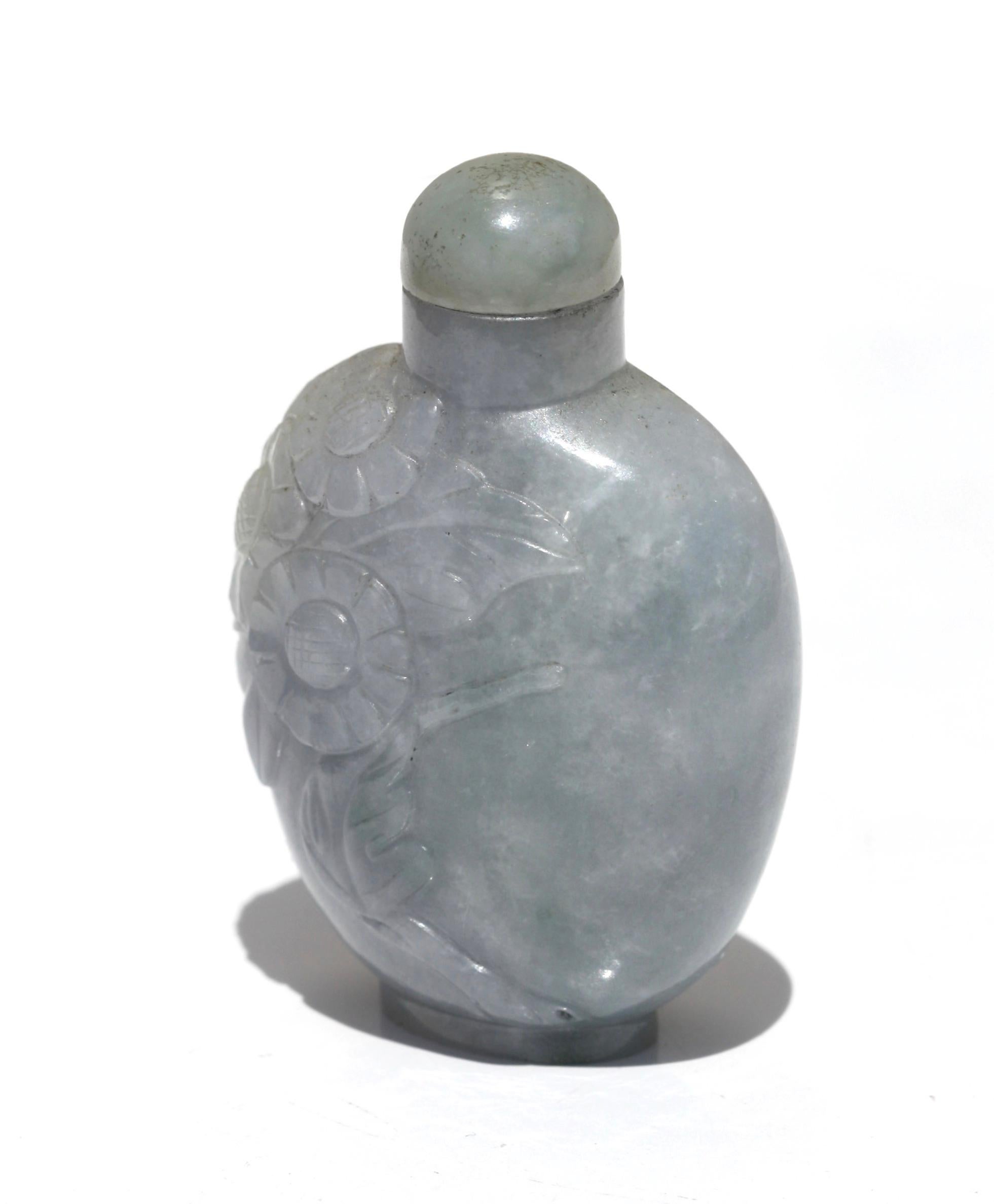 A Chinese carved jade snuff bottle and stopper
the flattened globular body carved continuously with a flower, the stone of whitish-grey and lavender tone, jade stopper
Measures: 5.72 cm, 2.25 in.