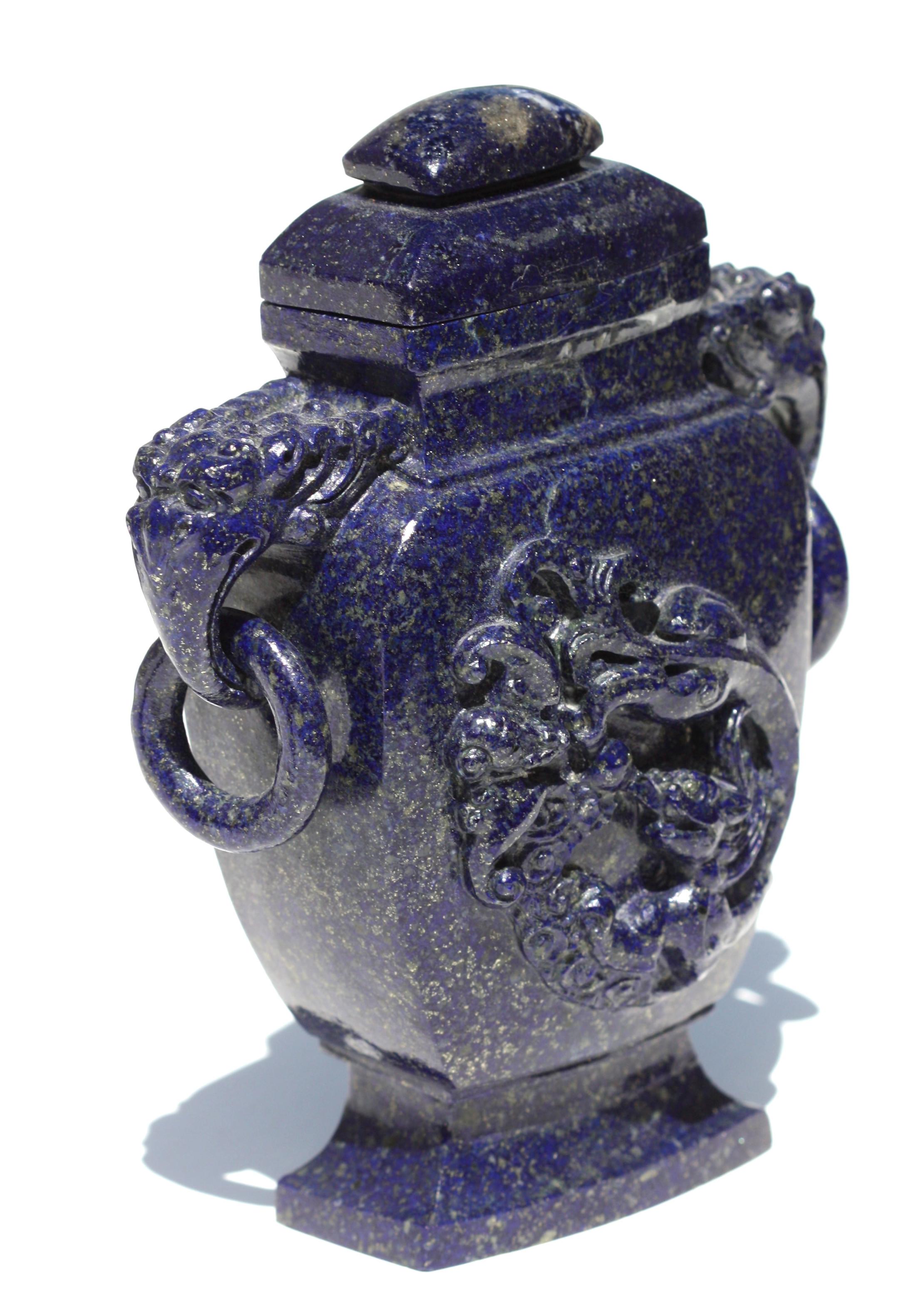 Chinesische geschnitzte Lapislazuli-Vase mit Deckel, 19./20. Jahrhundert,
flankiert von Henkeln mit Elefantenköpfen, die lose Ringe tragen, auf der einen Seite mit einem tief geschnitzten Drachen, auf der anderen Seite ungeschnitzt, auf einem