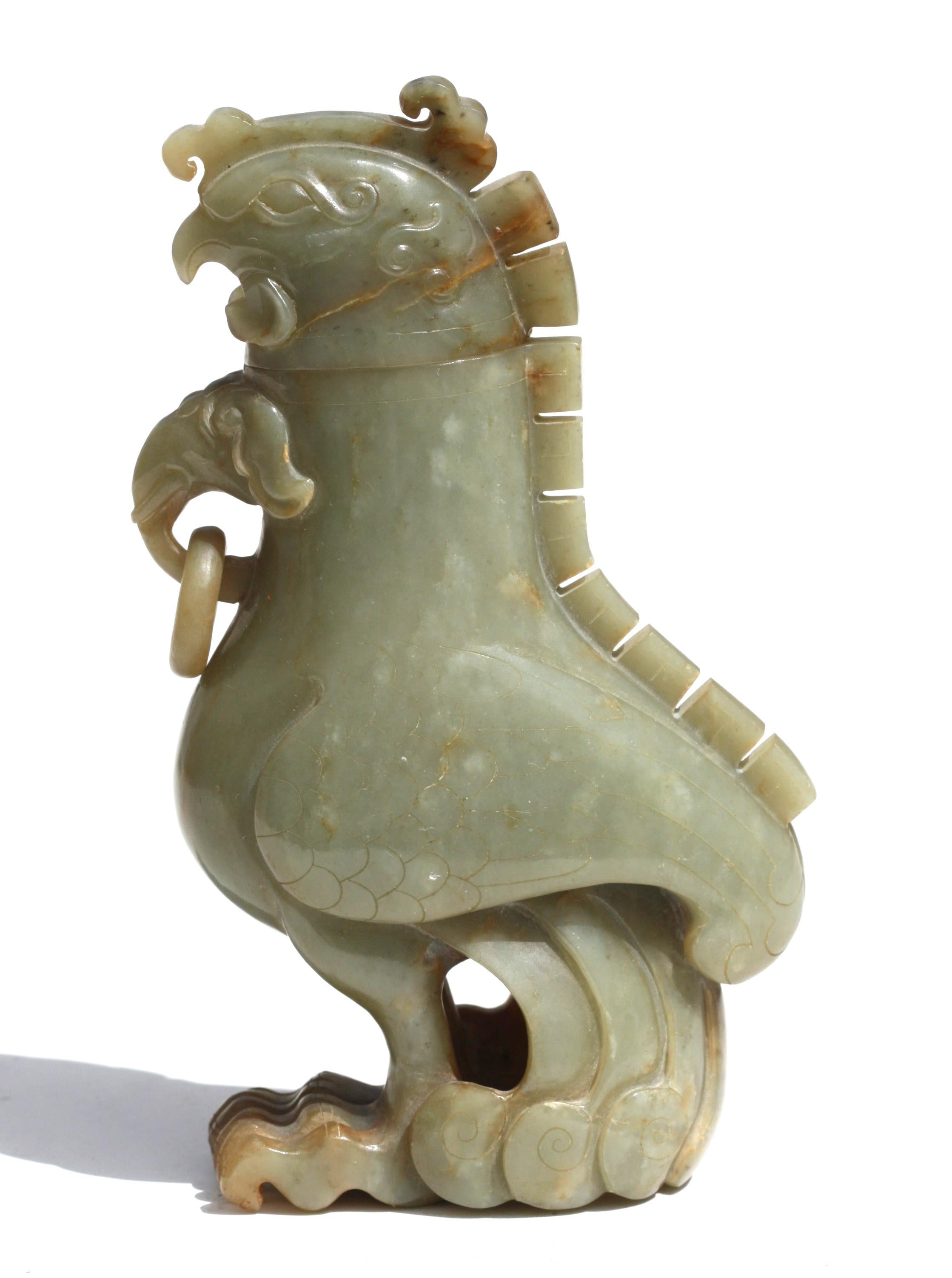 Un vase et un couvercle chinois sculptés en caledon pâle
Sculptée sous la forme d'un « poulet mythique » debout, debout avec un long plumage, le col avant a une tête d'éléphant mythique très inhabituelle avec des défenses et un anneau sculpté