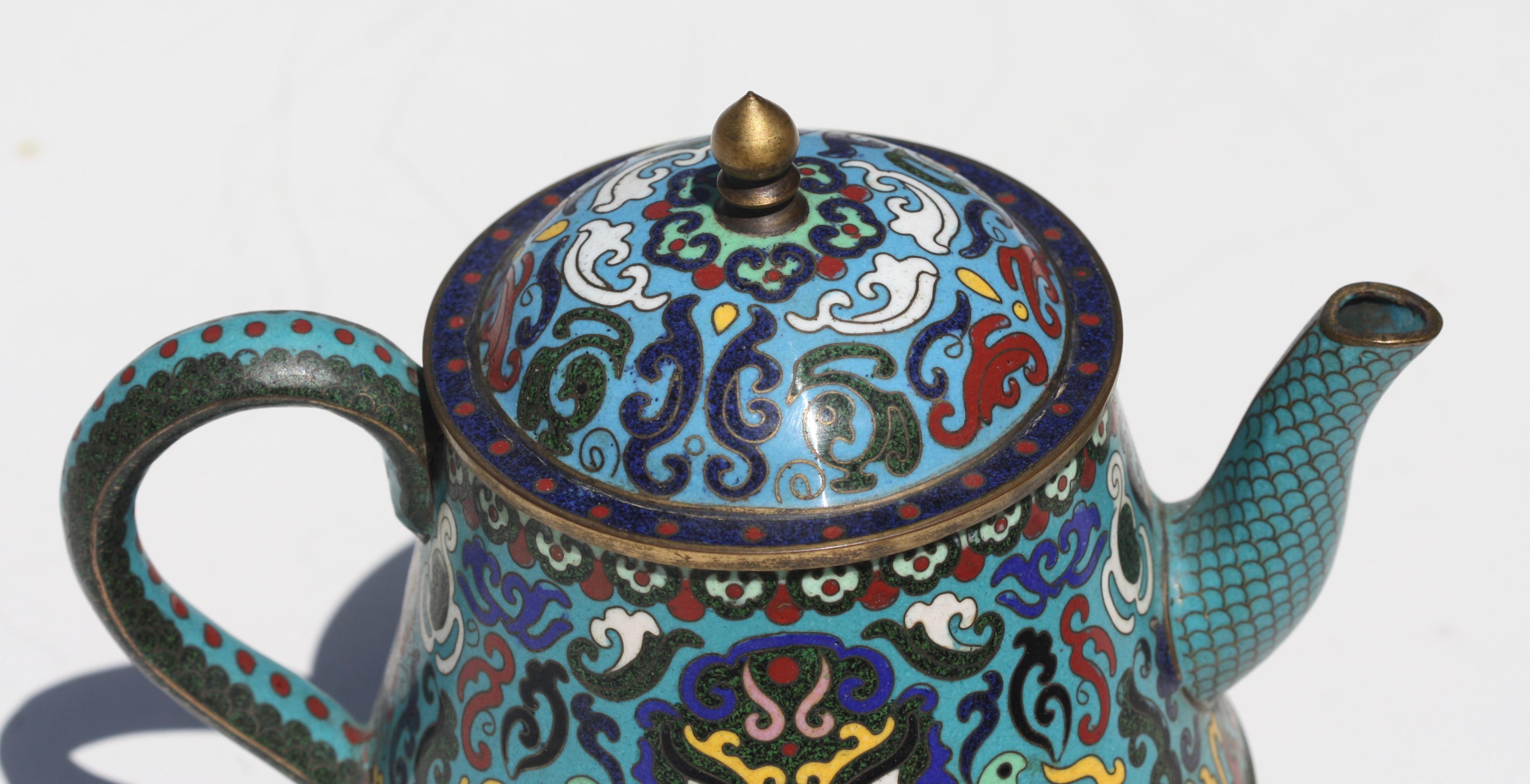 A Chinese cloisonné enamel teapot and cover, 20th century
gilt-decorated and enamelled with shuangxi characters and lotus flowers wreathed by dense foliage
Measures: Height 5.5 in. (13.97 cm.), 
Width 6.75 in. (17.14 cm.), 
Depth 4.25 in. (10.79