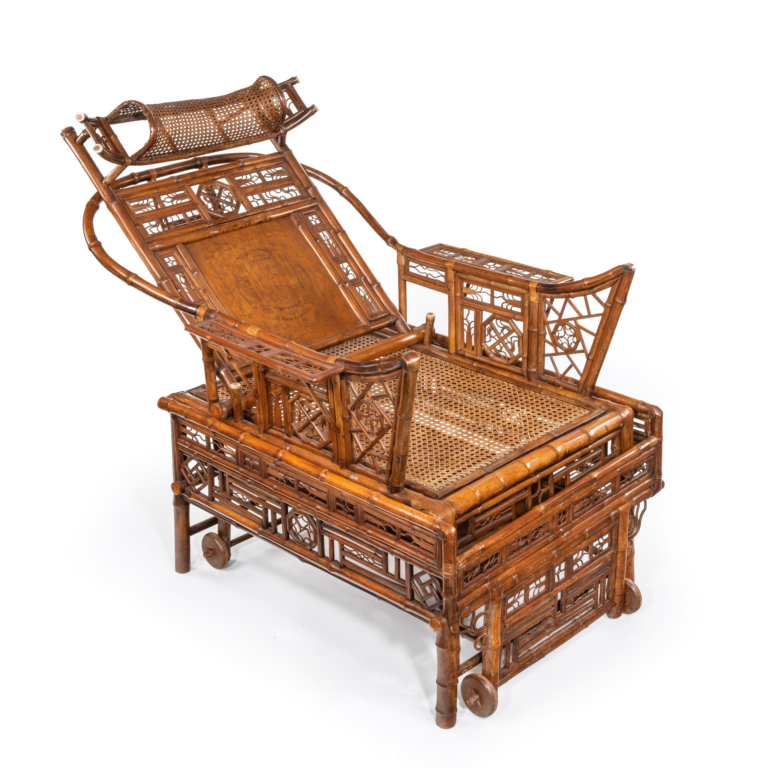A Chinese Export ‘Brighton Pavilion’ bamboo adjustable day bed, possibly Canton, decorated throughout with pierced geometric and foliate motifs, the angle adjustable back rest above a caned rectangular seat flanked by armrests, the base